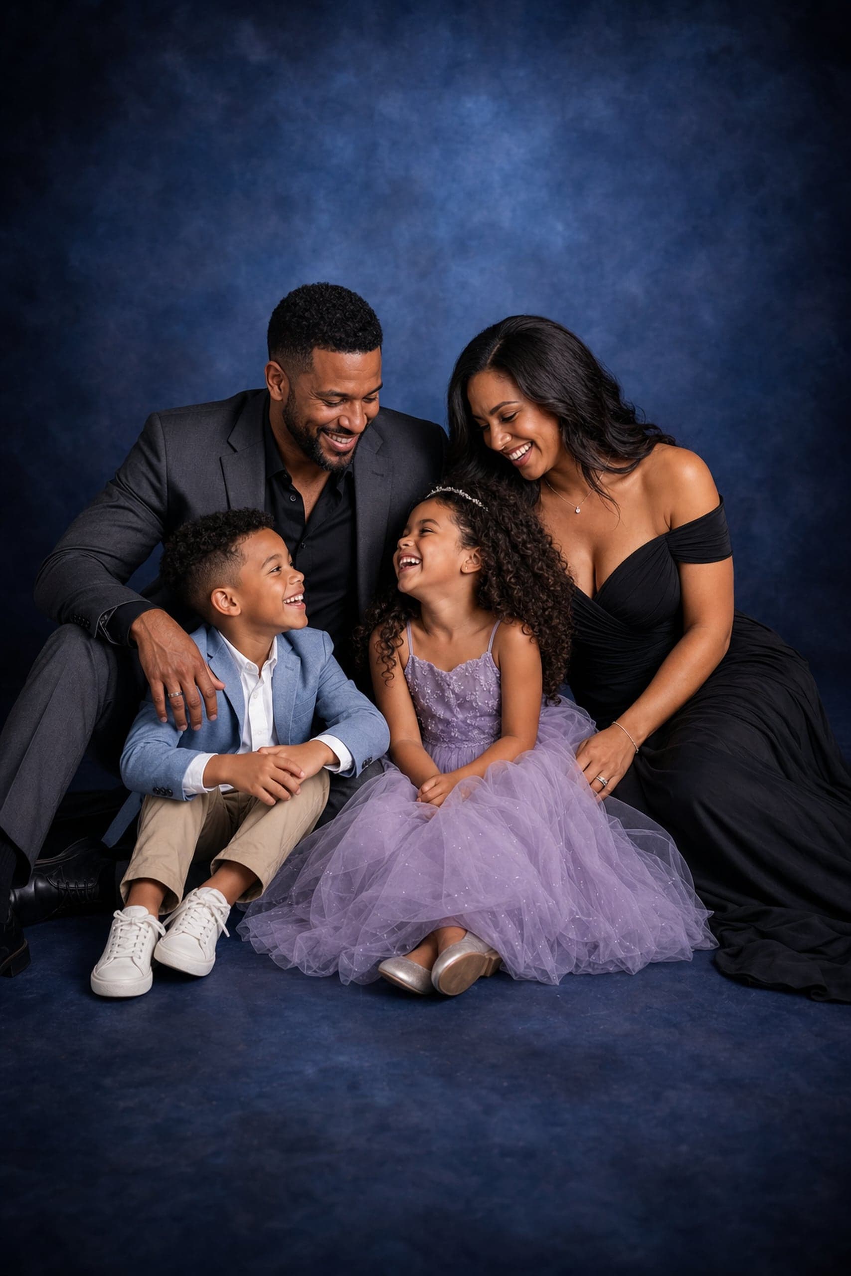 Family portrait seated on a deep-blue painterly backdrop