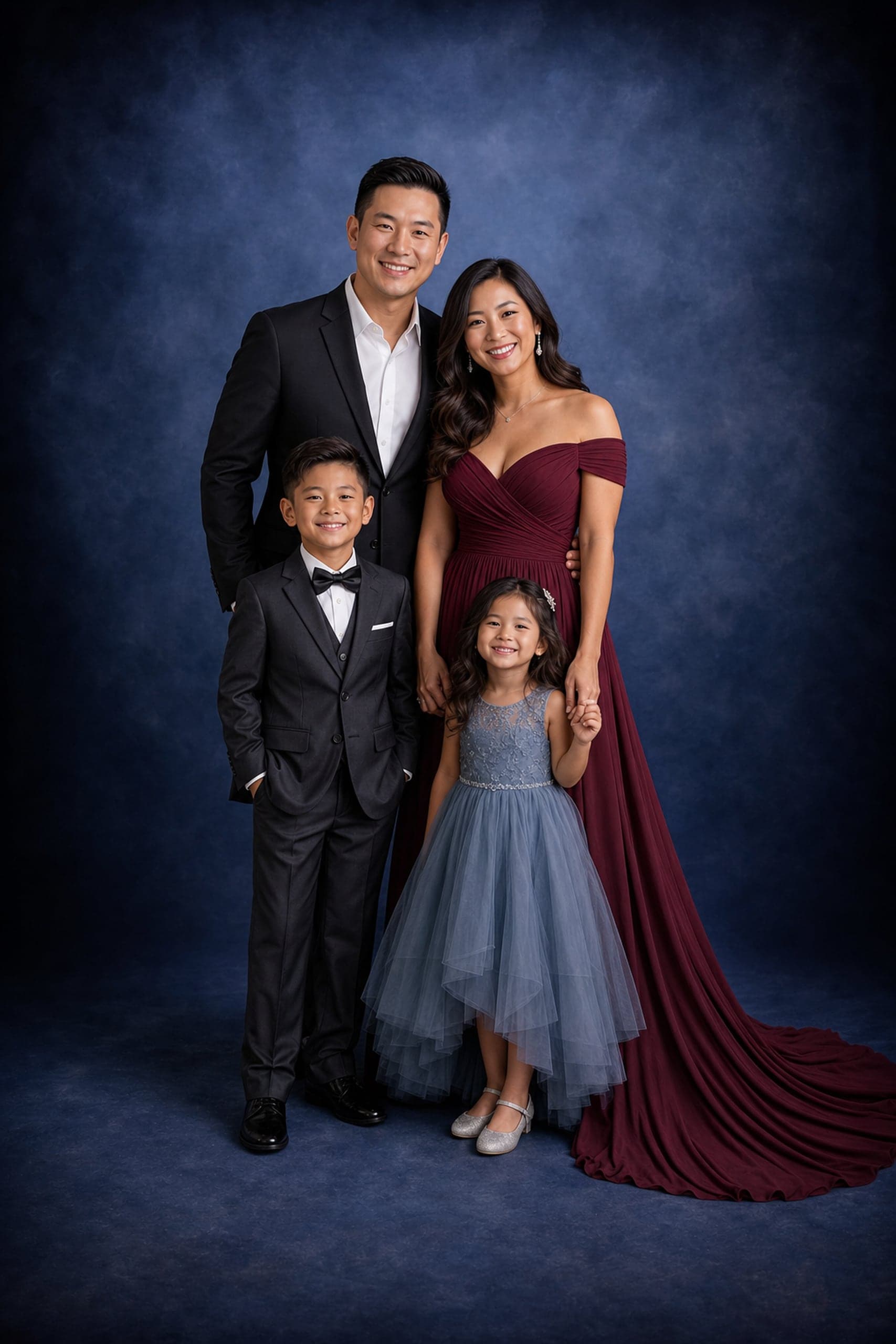 Formal family portrait of four on a deep-blue backdrop