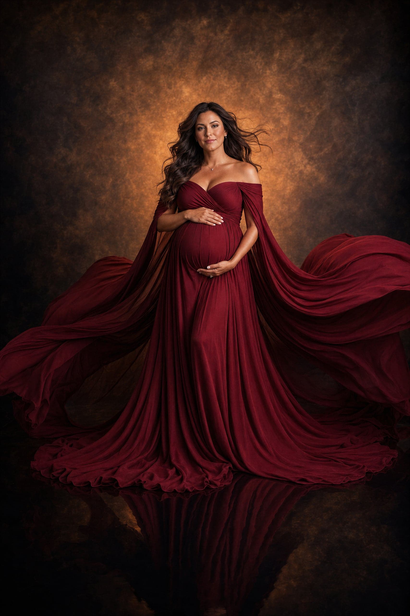 Maternity portrait in a burgundy gown with flowing fabric