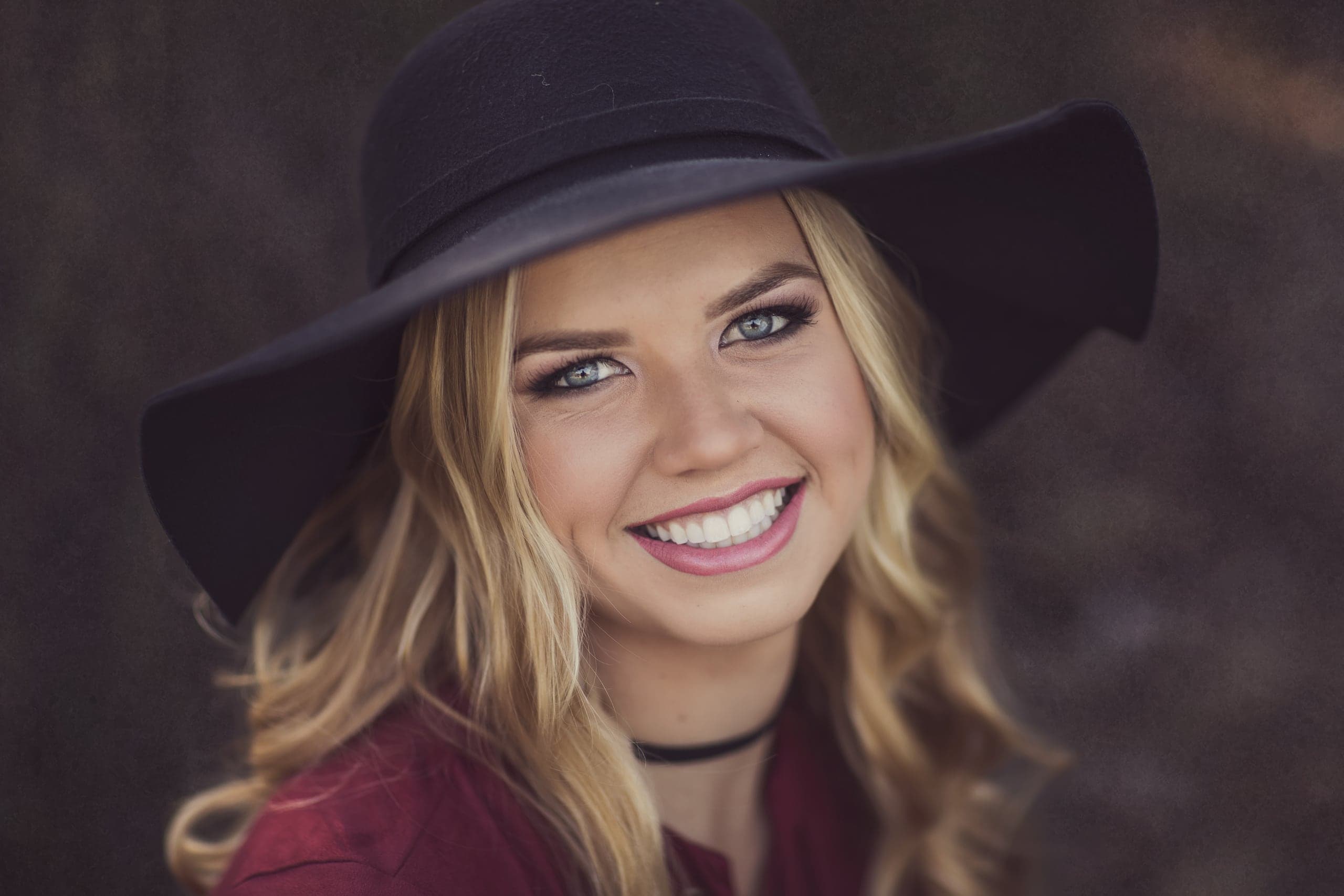 Senior portrait in a wide-brim hat at golden hour