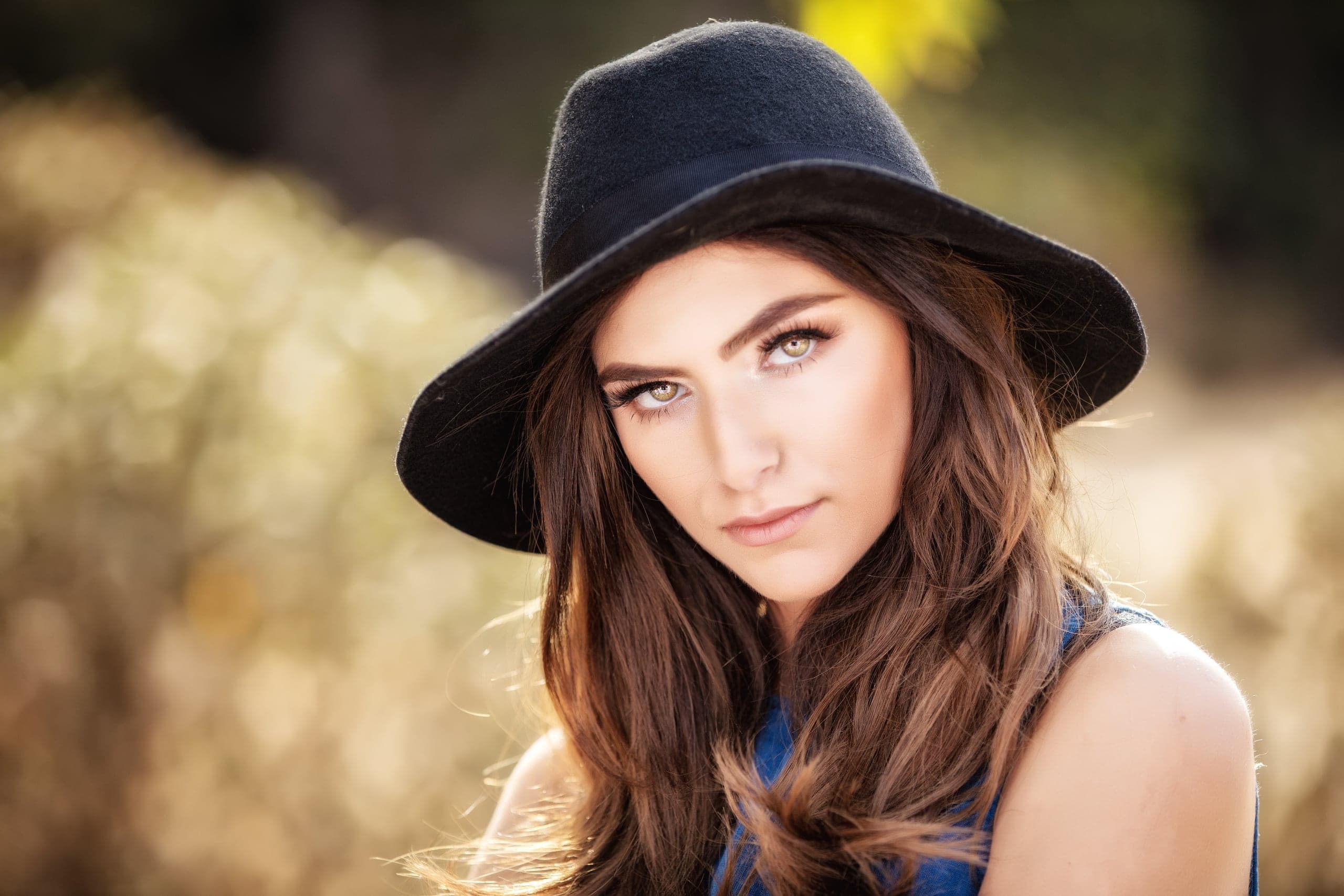 Senior portrait in a hat in a golden field