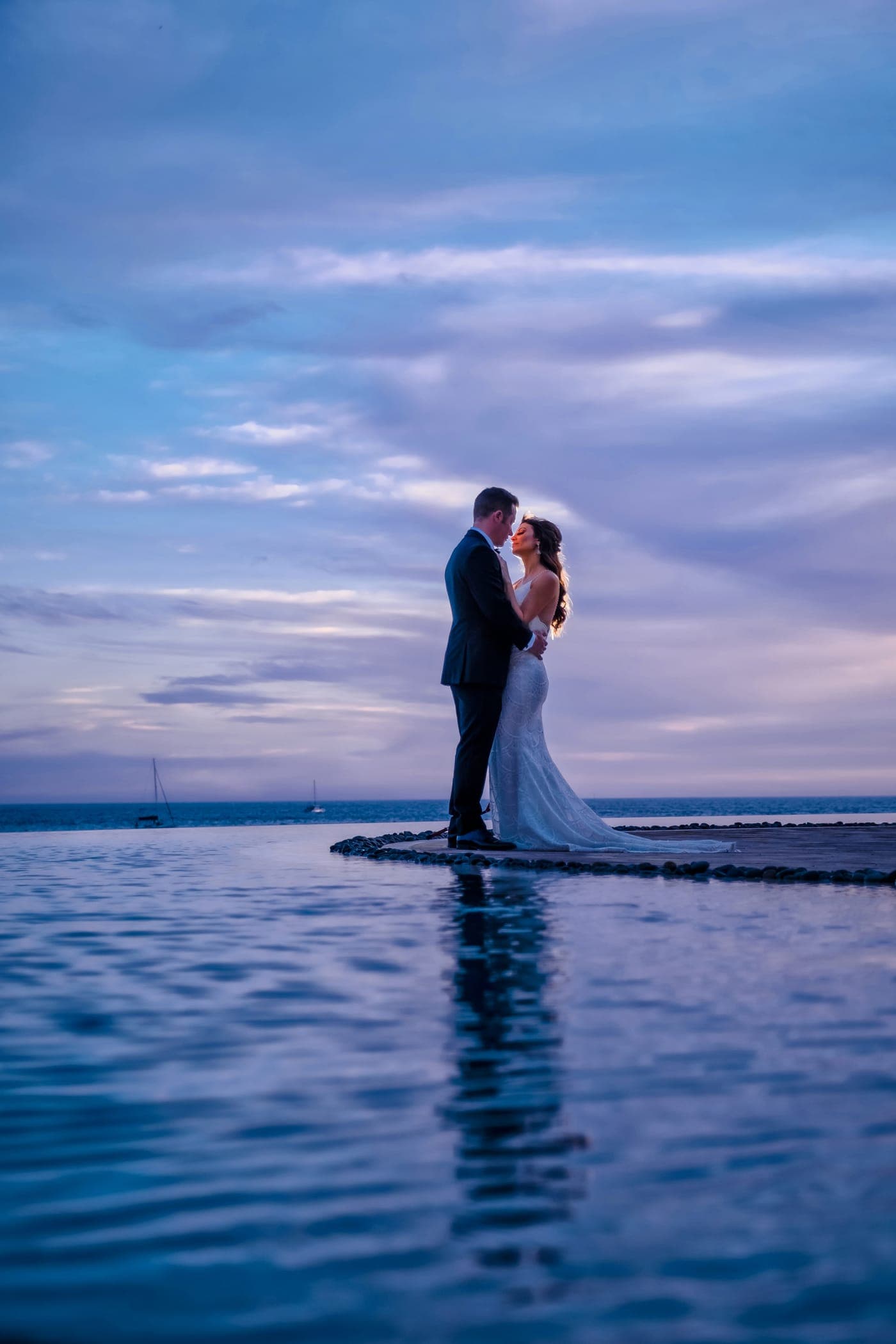A bride and groom beside an infinity pool at Grand Solmar