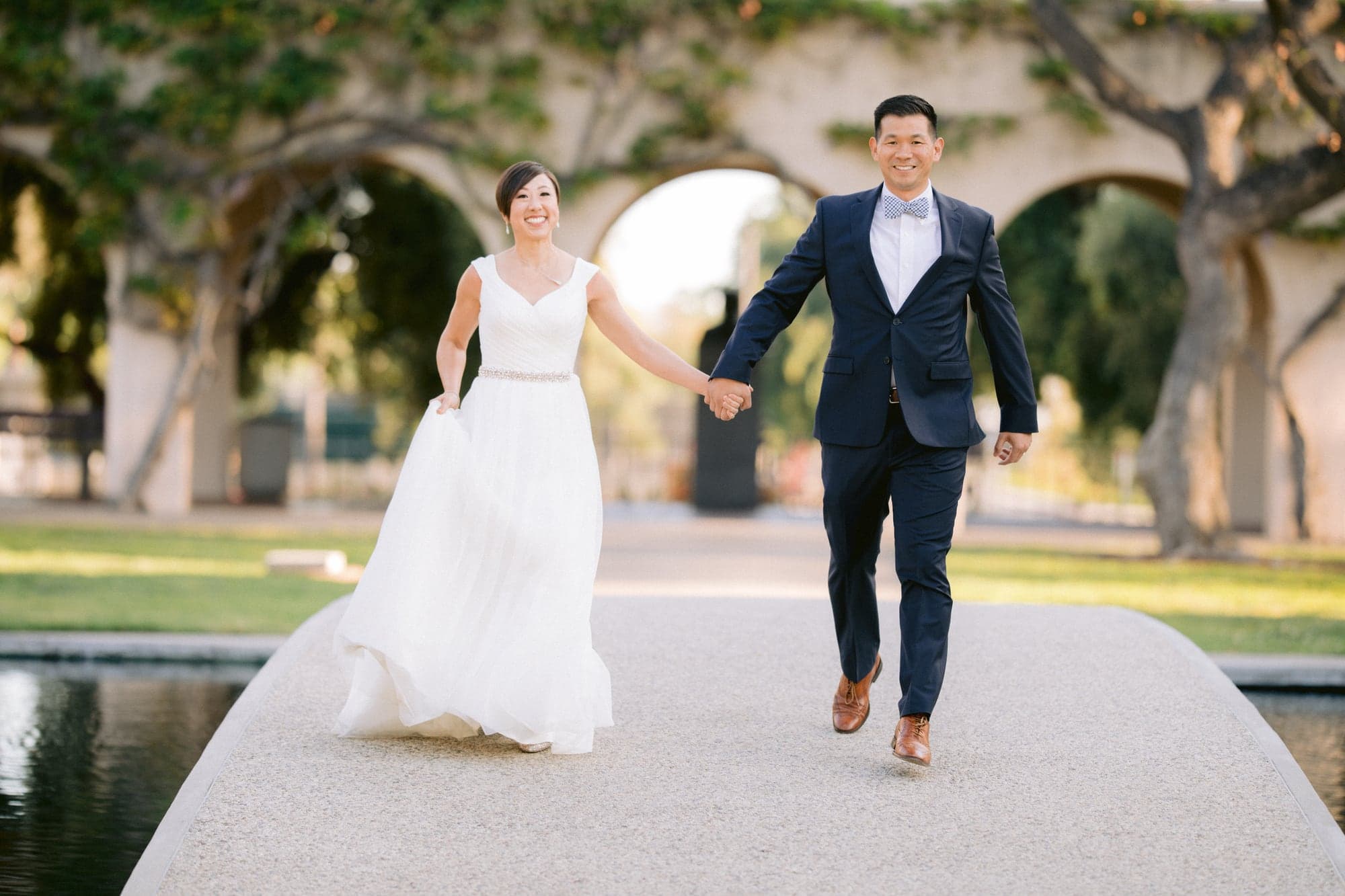 Wedding couple walking beside a Caltech reflecting pool