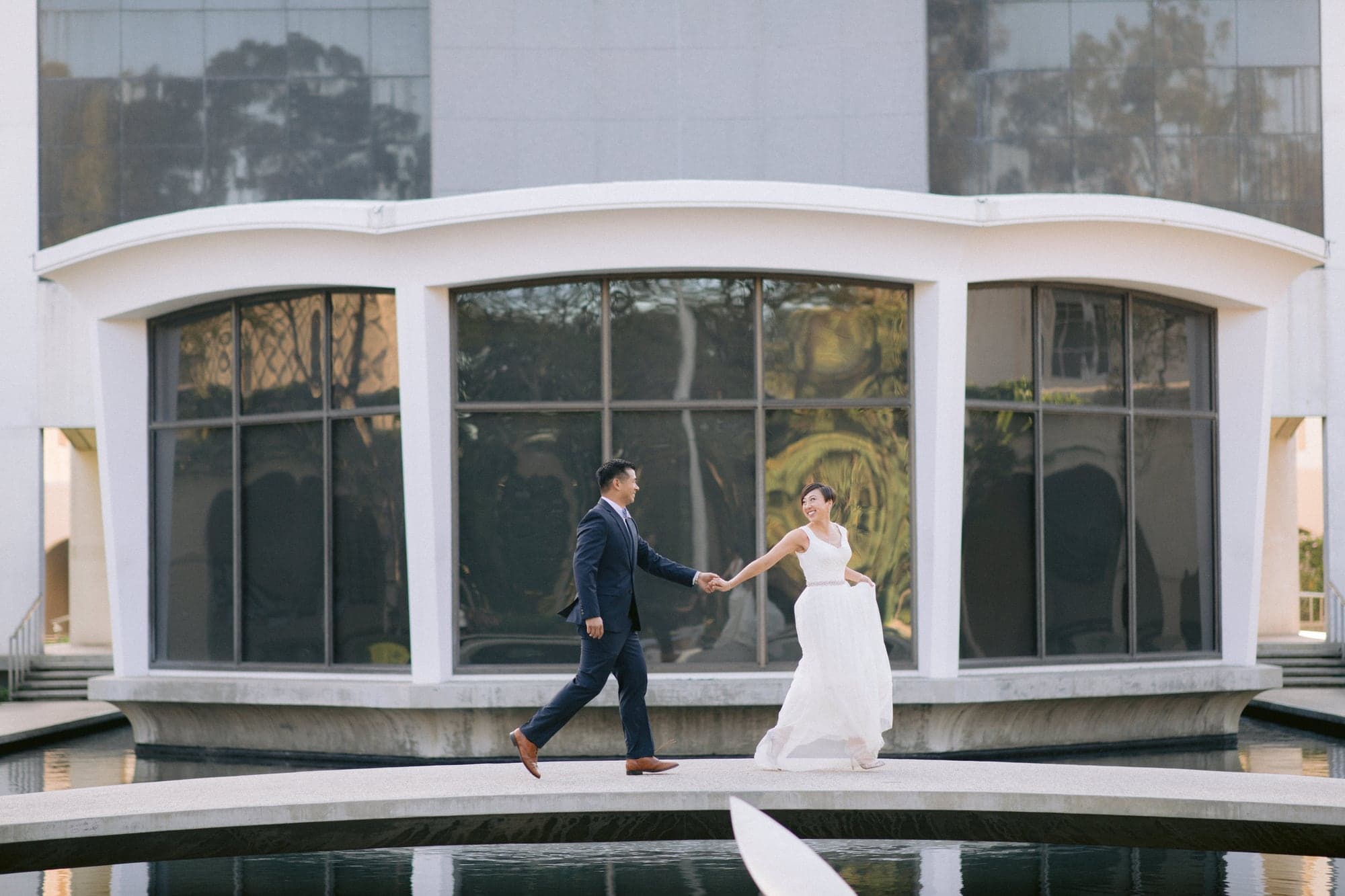Wedding couple reflected in a modern glass building