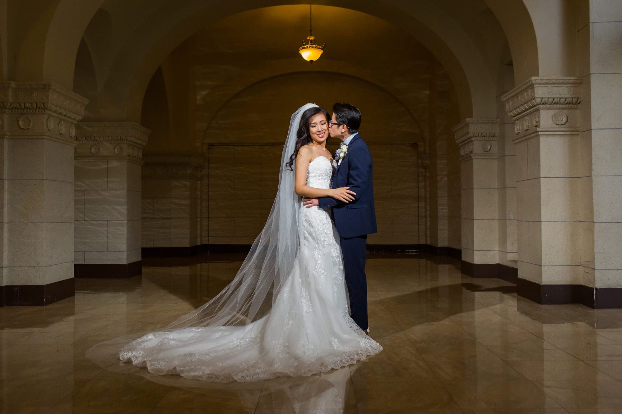 Bride framed by a tall historic window