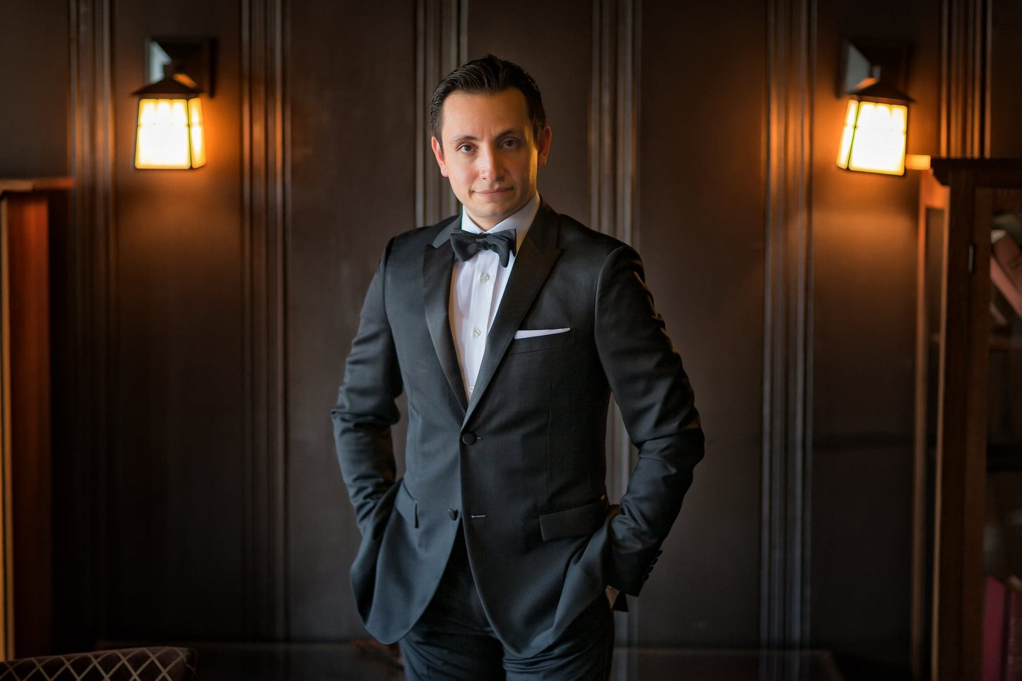 Groom preparing in warm window light before the Borozan wedding
