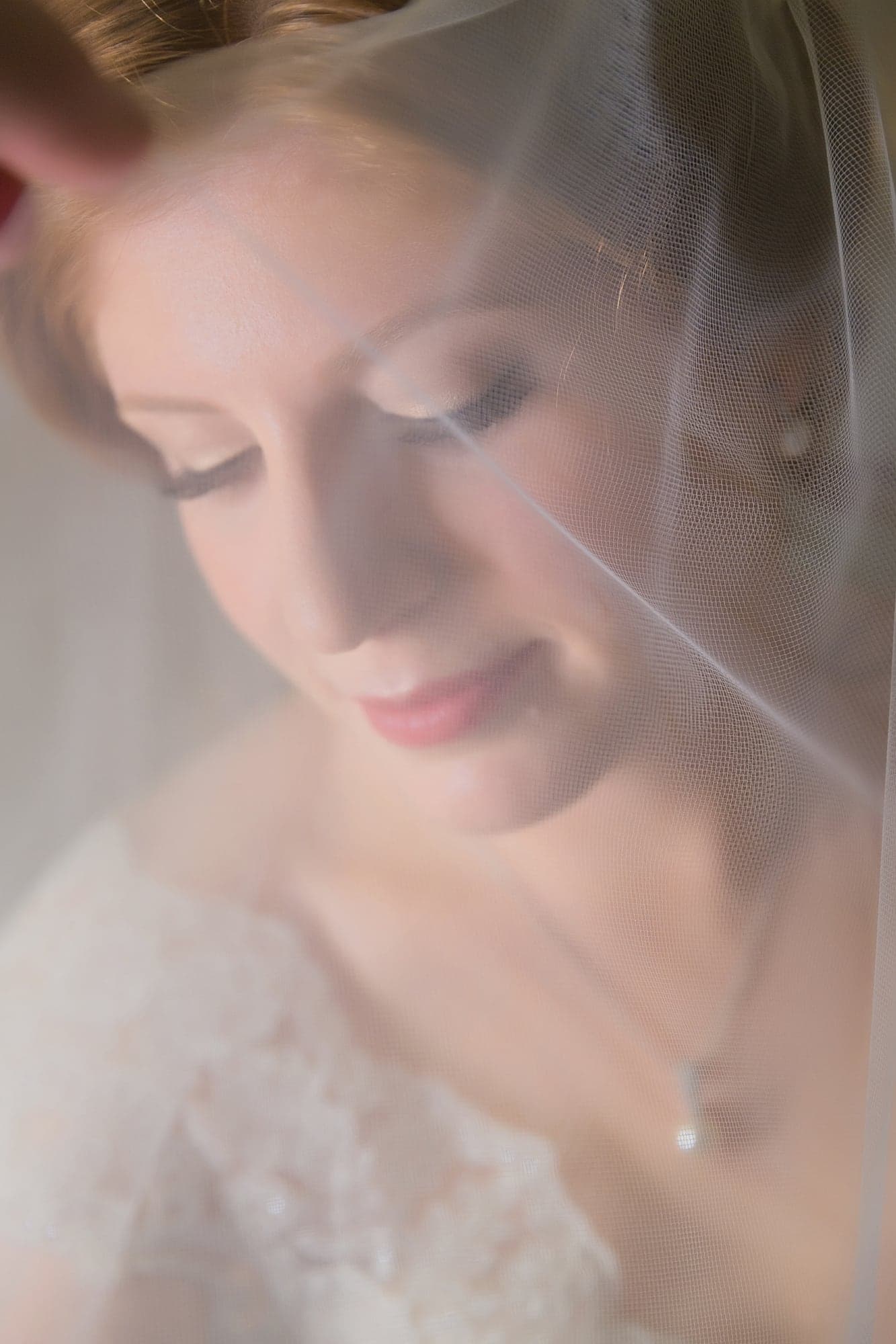 Bride in her lace gown and veil before the ceremony