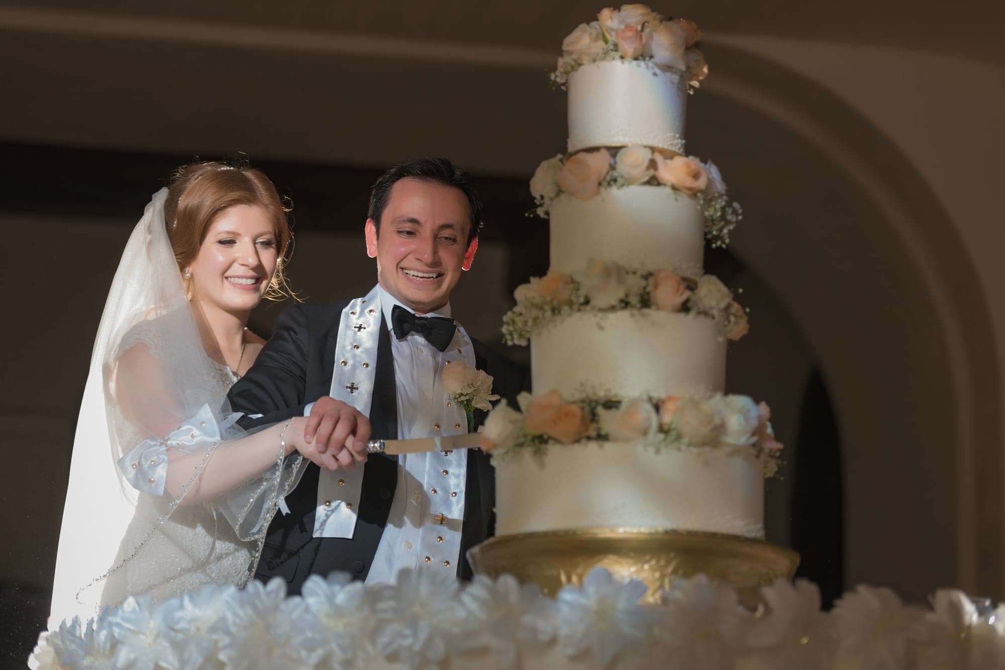 The newlyweds cutting their tiered wedding cake