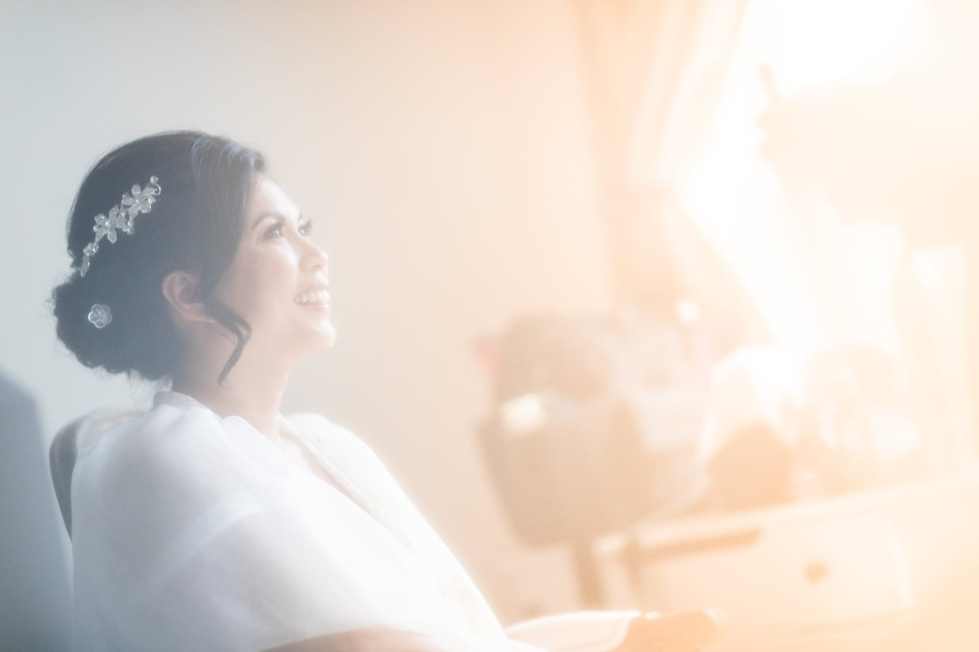 Bride in warm window light before the Reyrata wedding