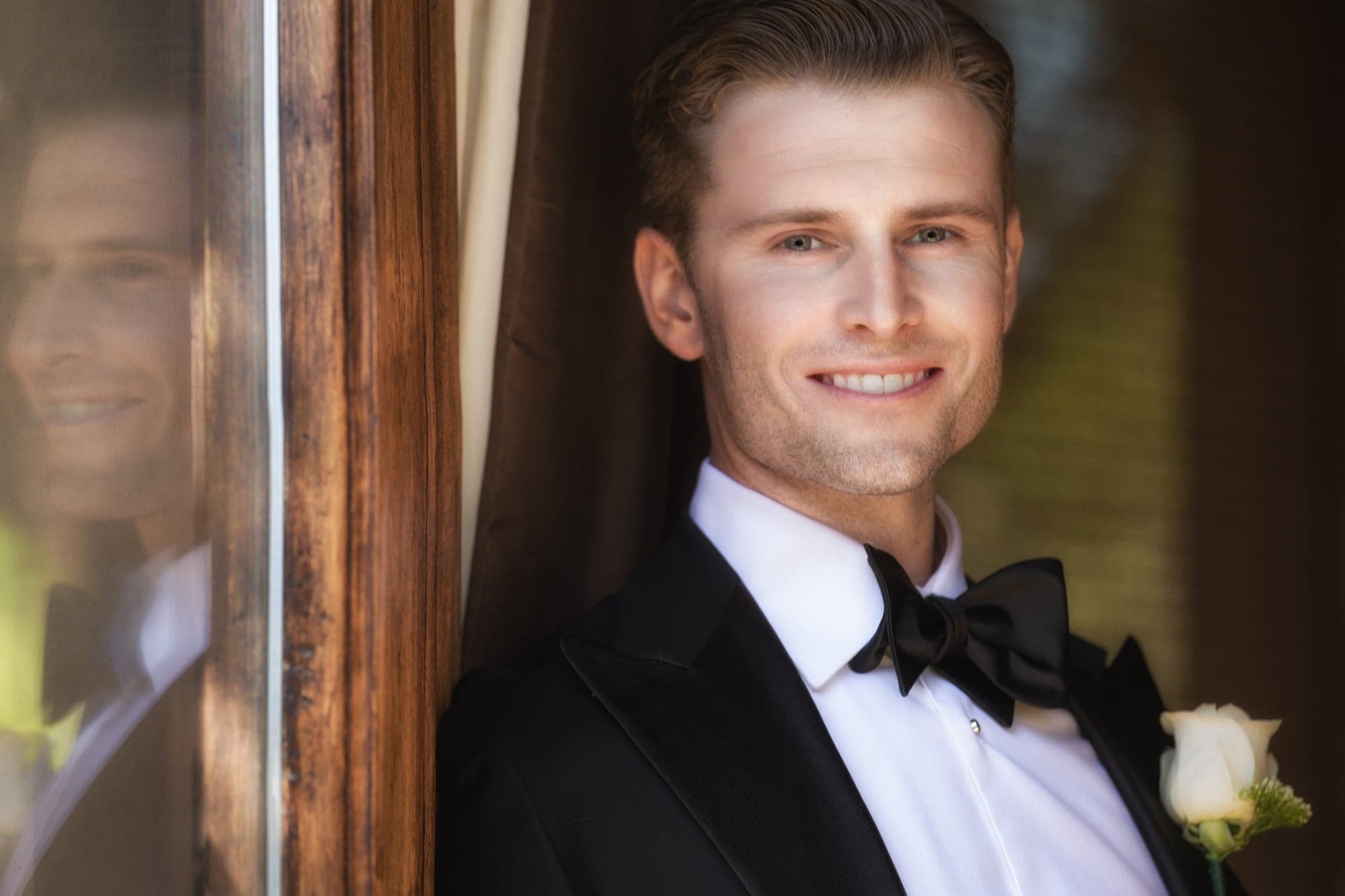 Groom preparing in a classic black tuxedo