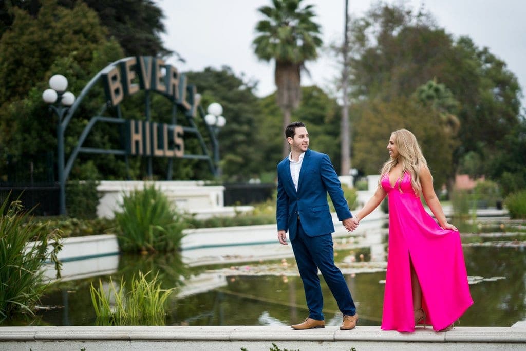 The Beverly Hills sign and lily pond in Beverly Gardens Park, with palm-lined Rodeo Drive nearby.