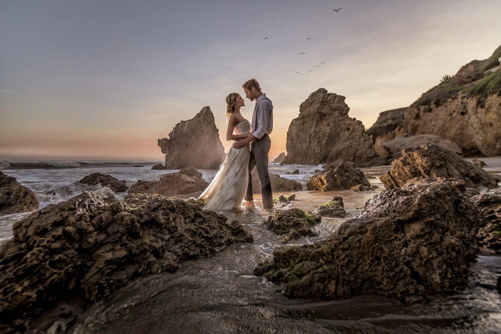 The sea stacks, natural arch, and sandy cove of El Matador State Beach in Malibu glowing in late-afternoon golden-hour light.