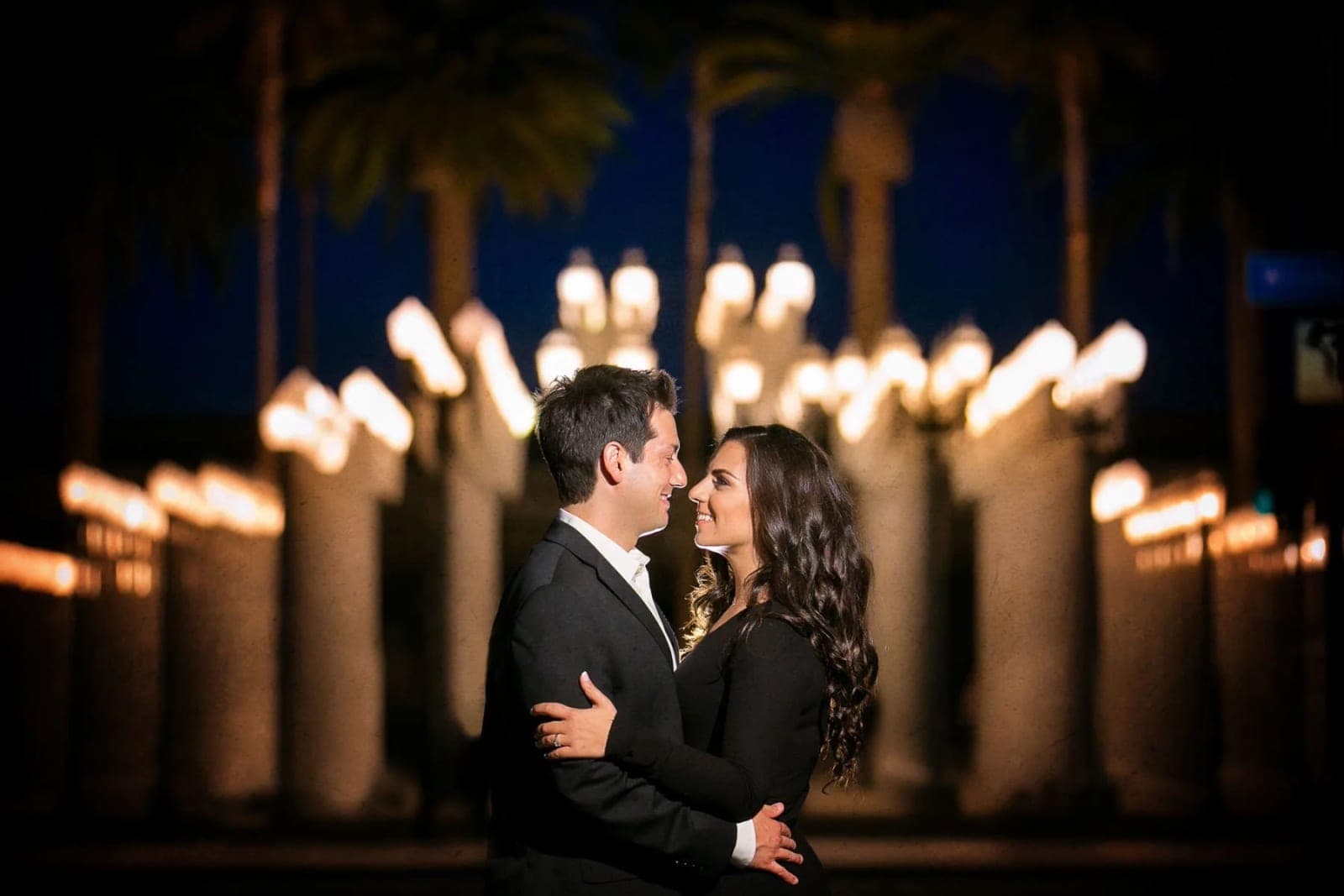 Chris Burden's Urban Light installation at LACMA, rows of glowing vintage street lamps on the Wilshire Boulevard plaza at dusk.