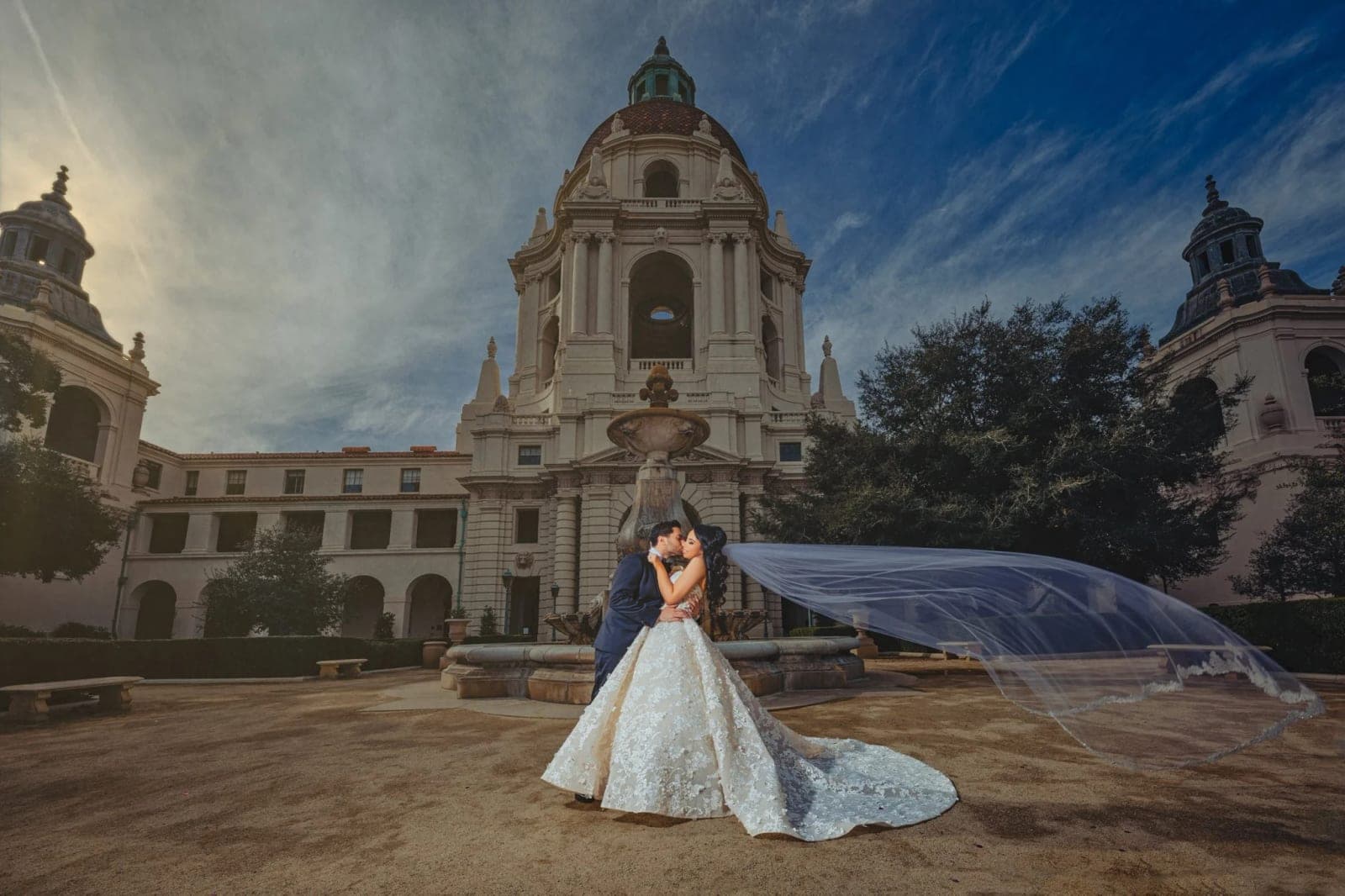 The Mediterranean-revival dome and arched courtyard colonnades of Pasadena City Hall glowing in warm golden-hour light.
