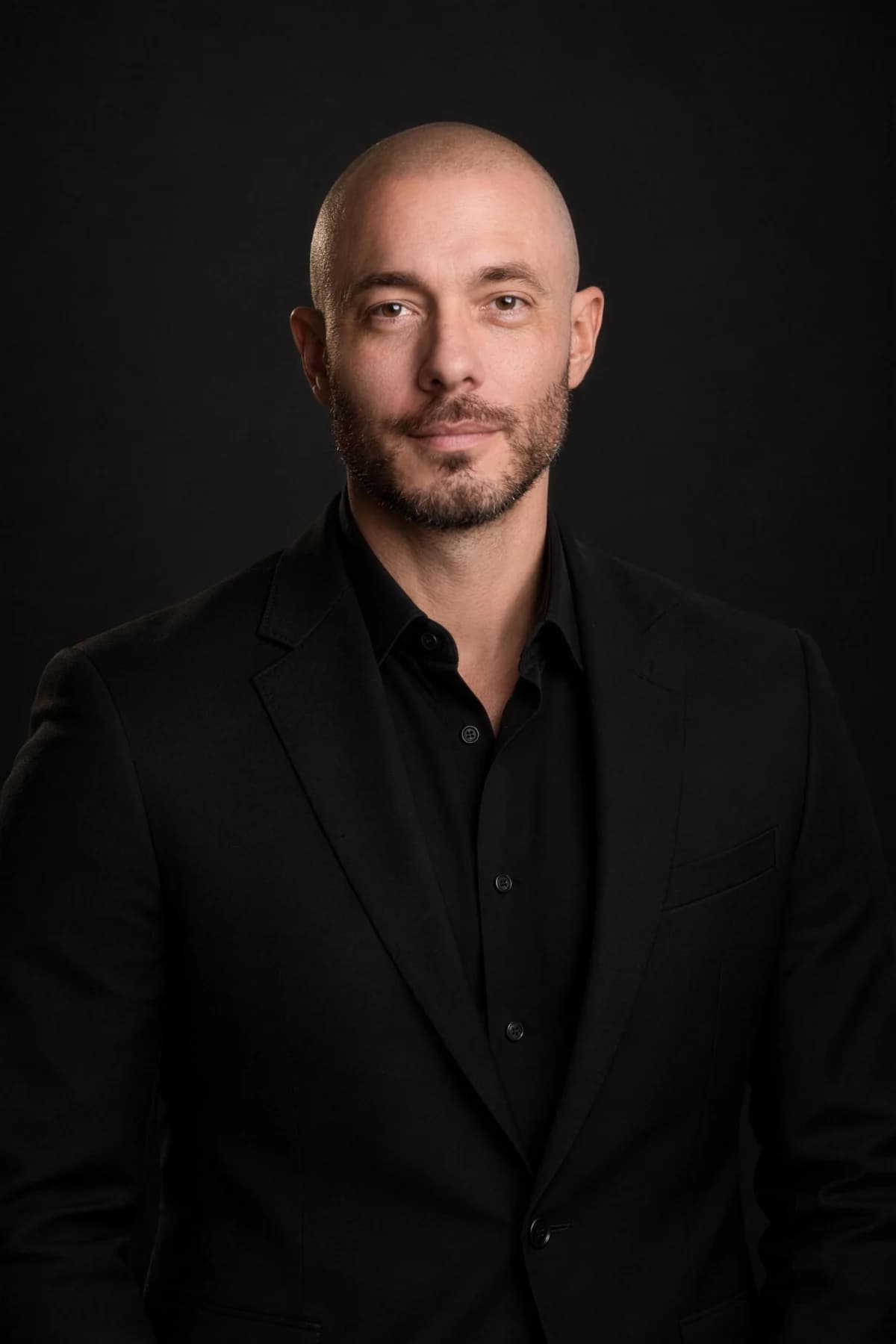 Michael Anthony in a black suit against a dark studio backdrop