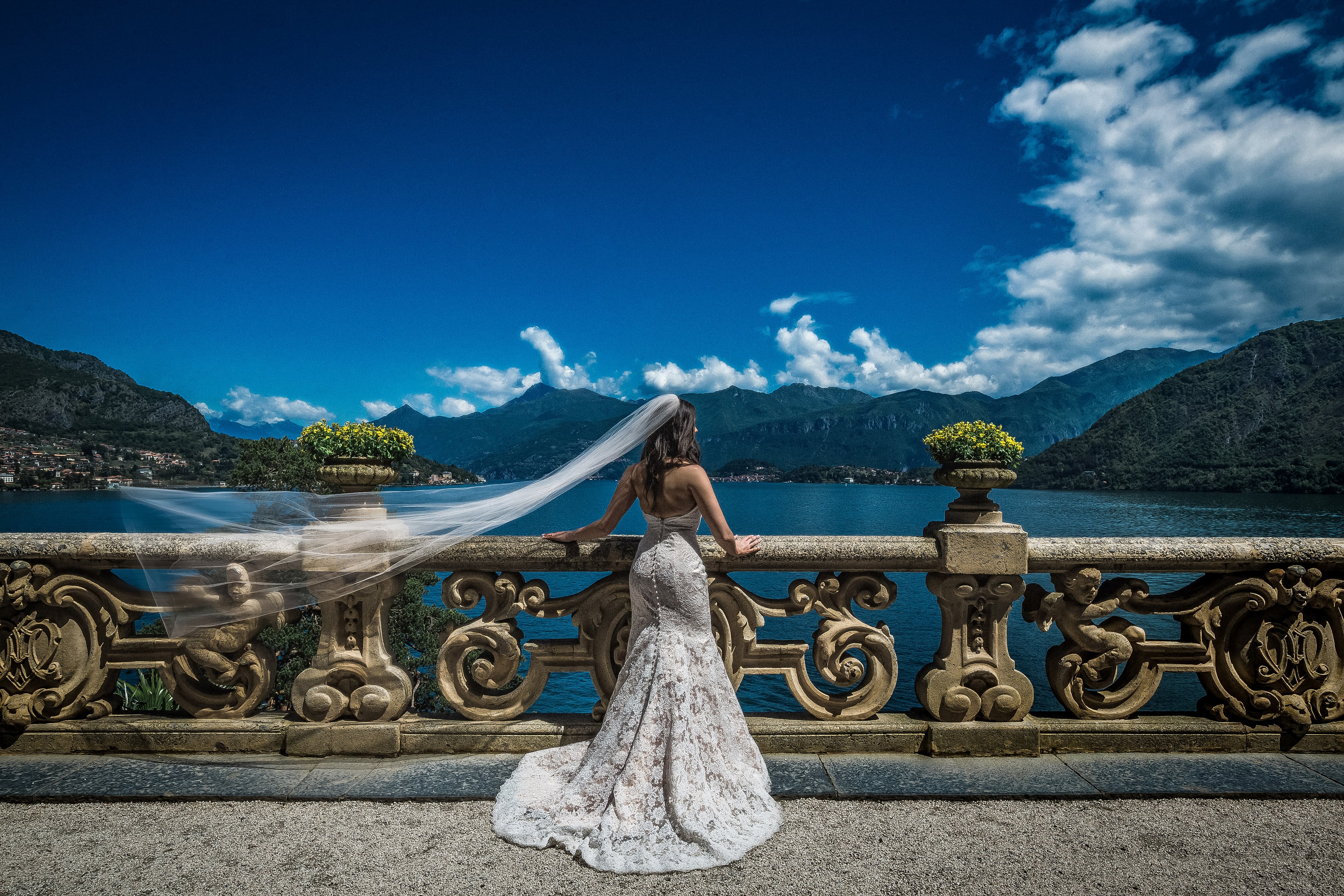 Bride overlooking Lake Como from an ornate stone terrace