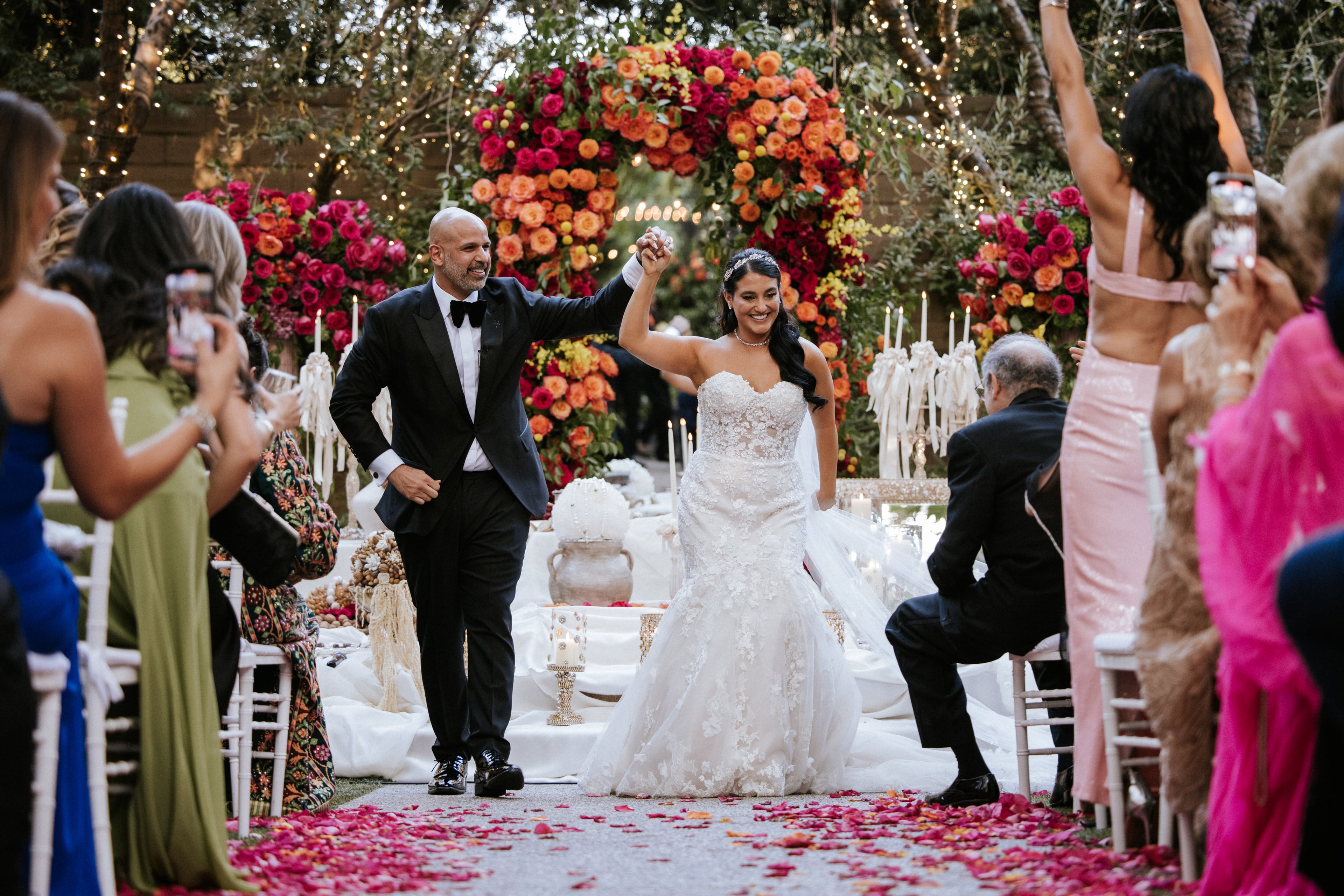 Newlyweds walking through a petal toss after their ceremony