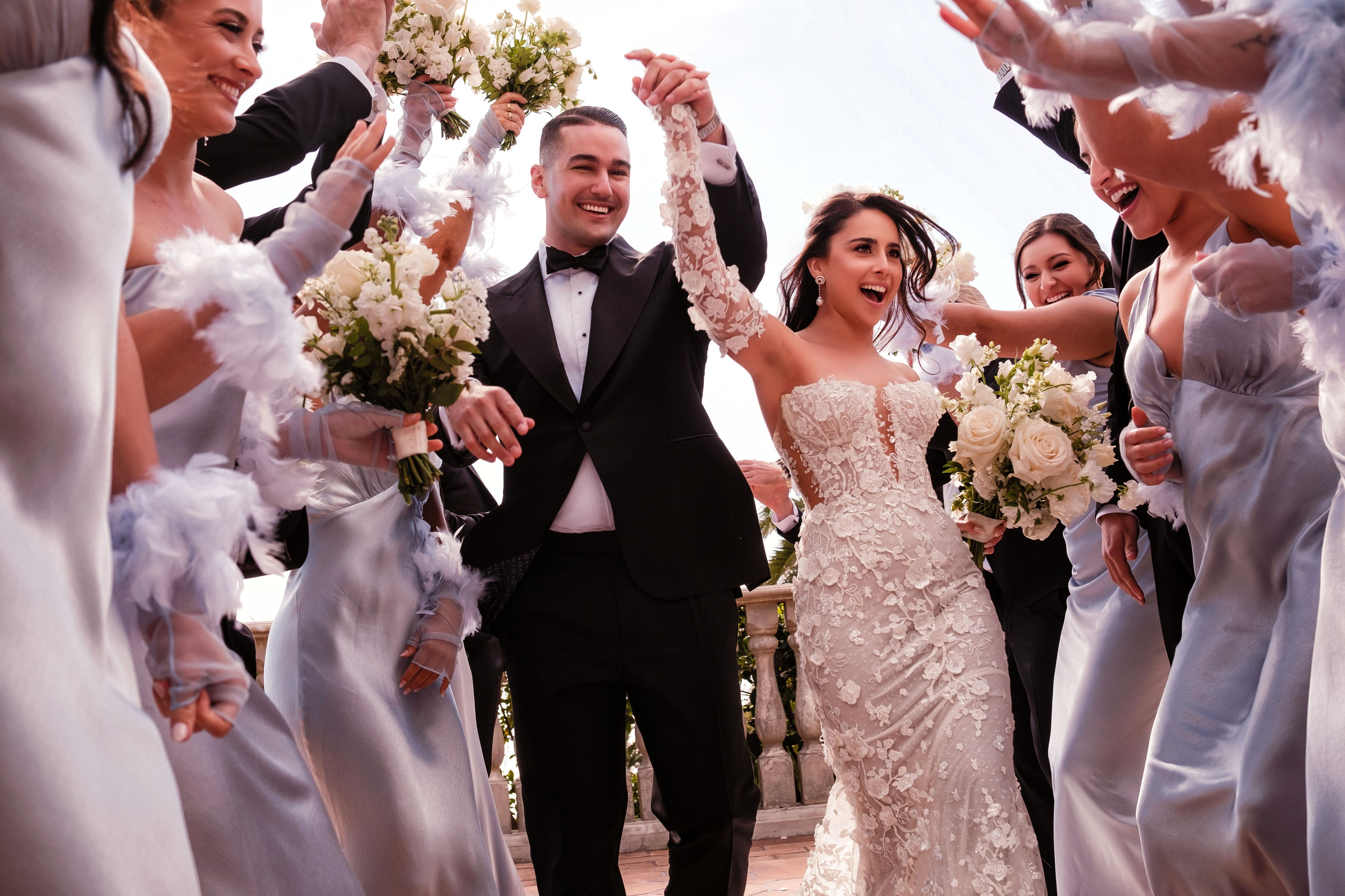 Newlyweds celebrating through a joyful wedding party tunnel