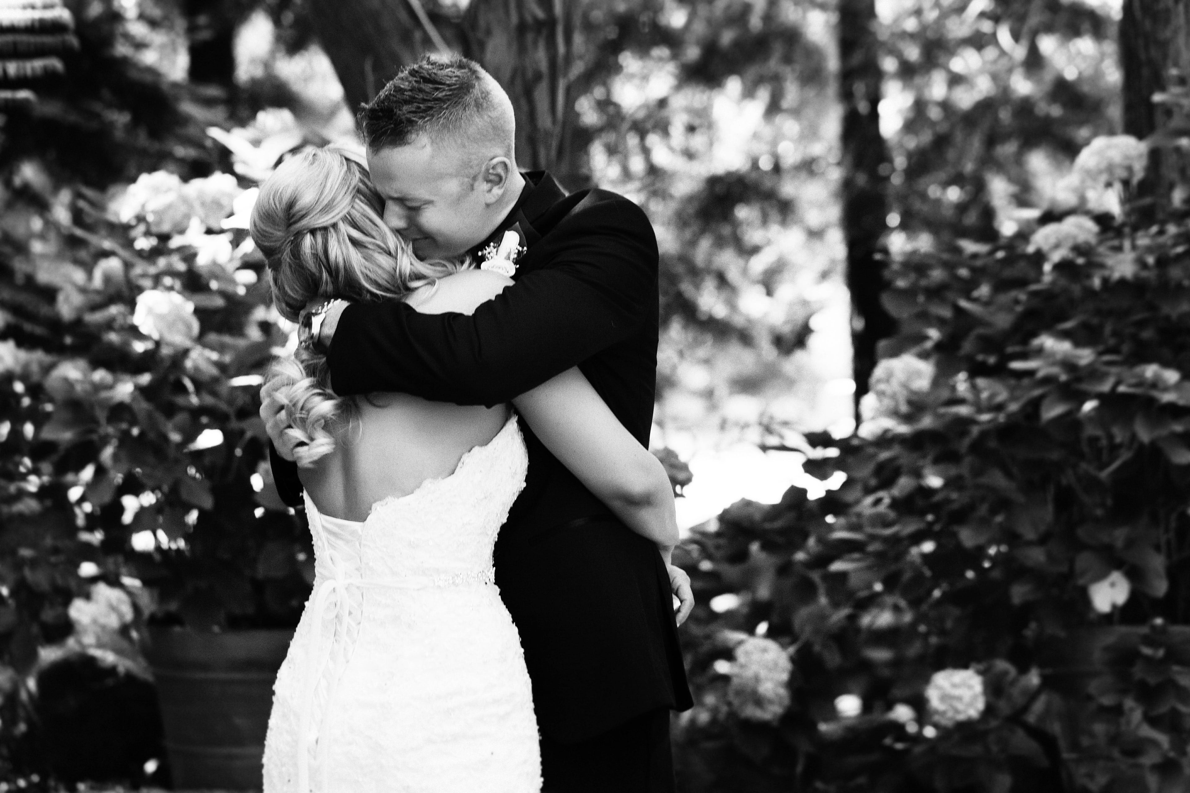 Newlyweds sharing an emotional black and white embrace