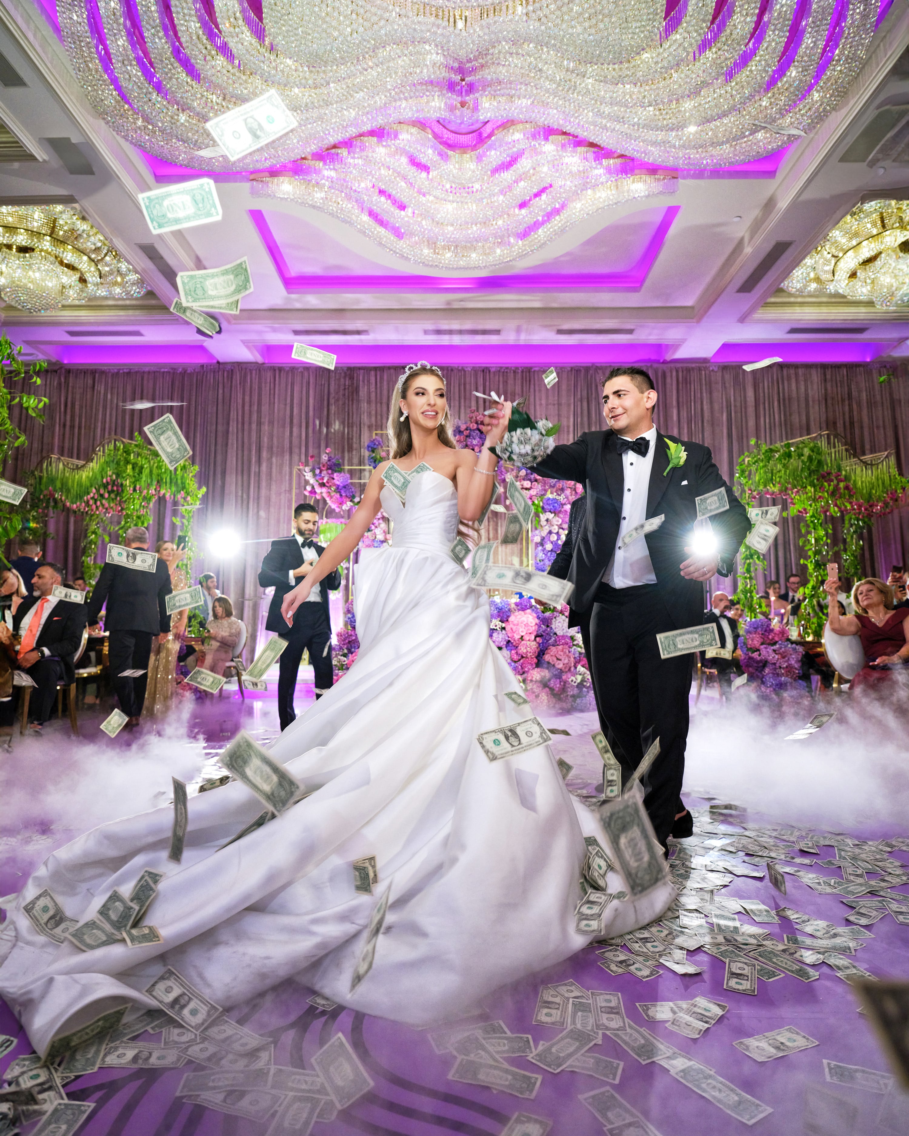Newlyweds entering a colorful ballroom reception
