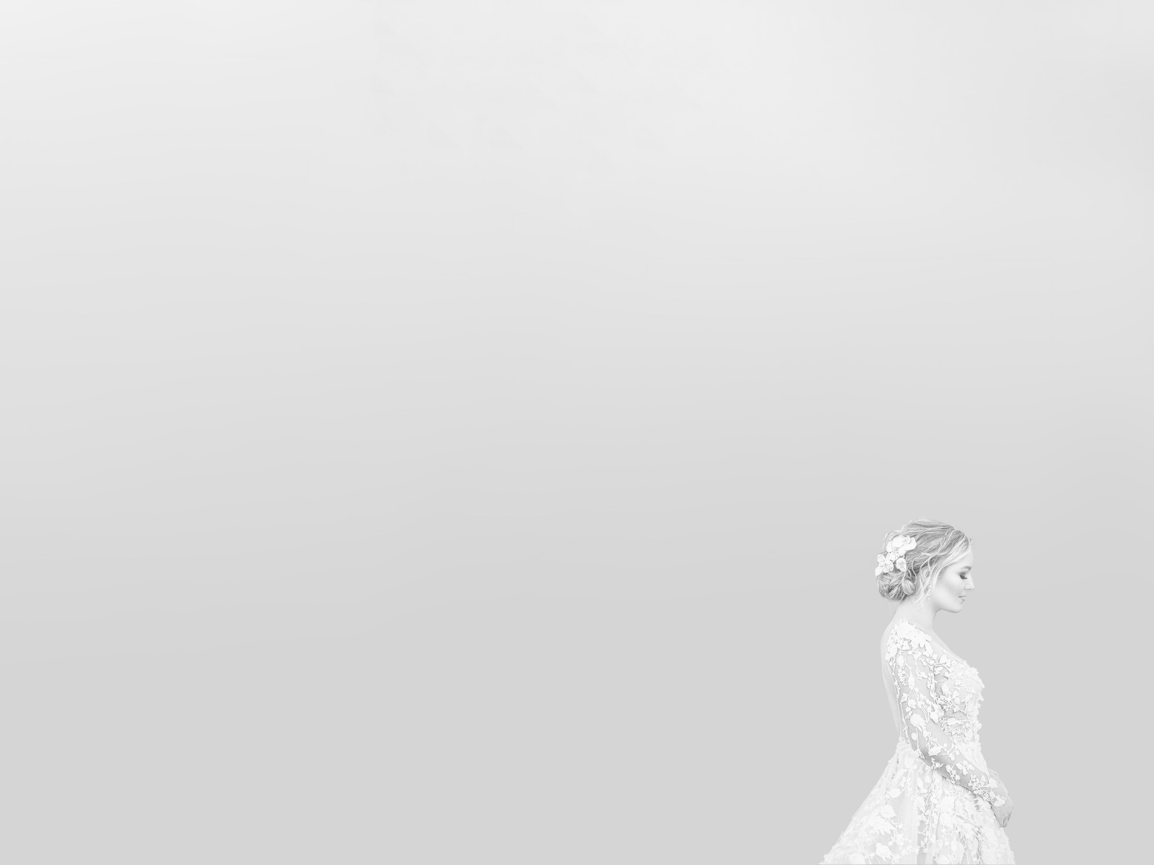 High-key bridal portrait with a long gown and delicate floral detail