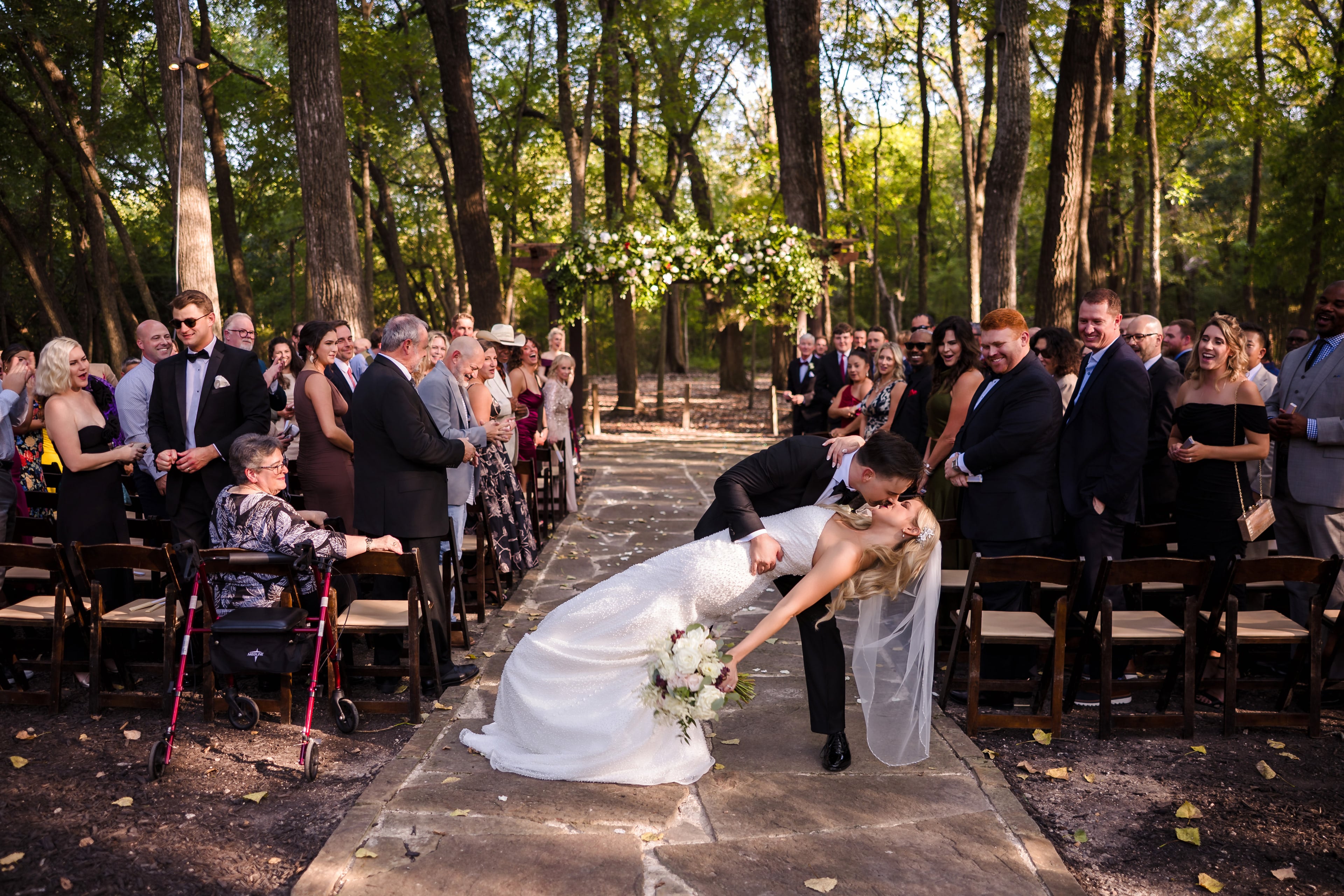 Newlyweds sharing a playful ceremony dip among their guests
