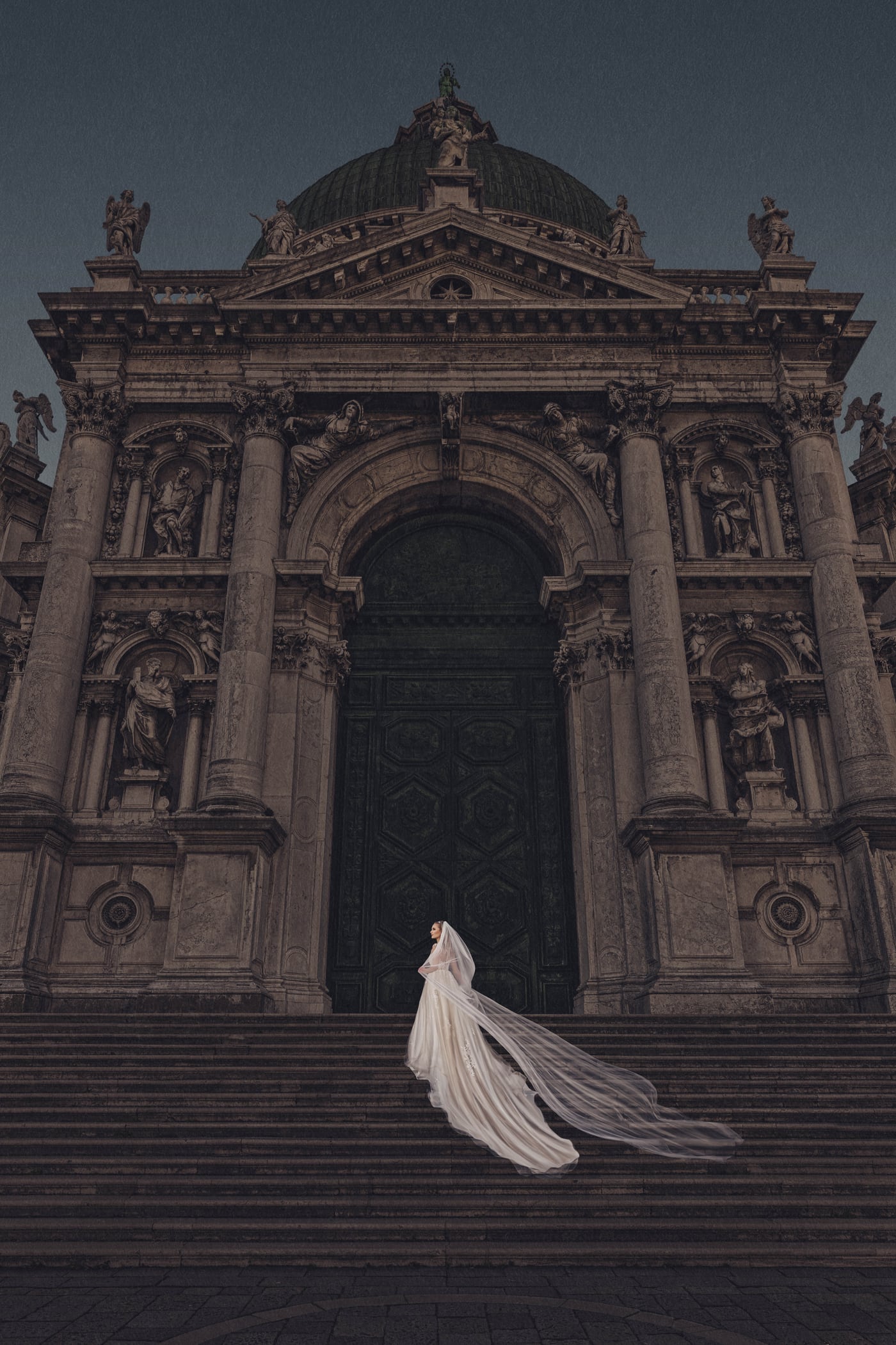 A bride with a flowing gown on the steps of an Italian church