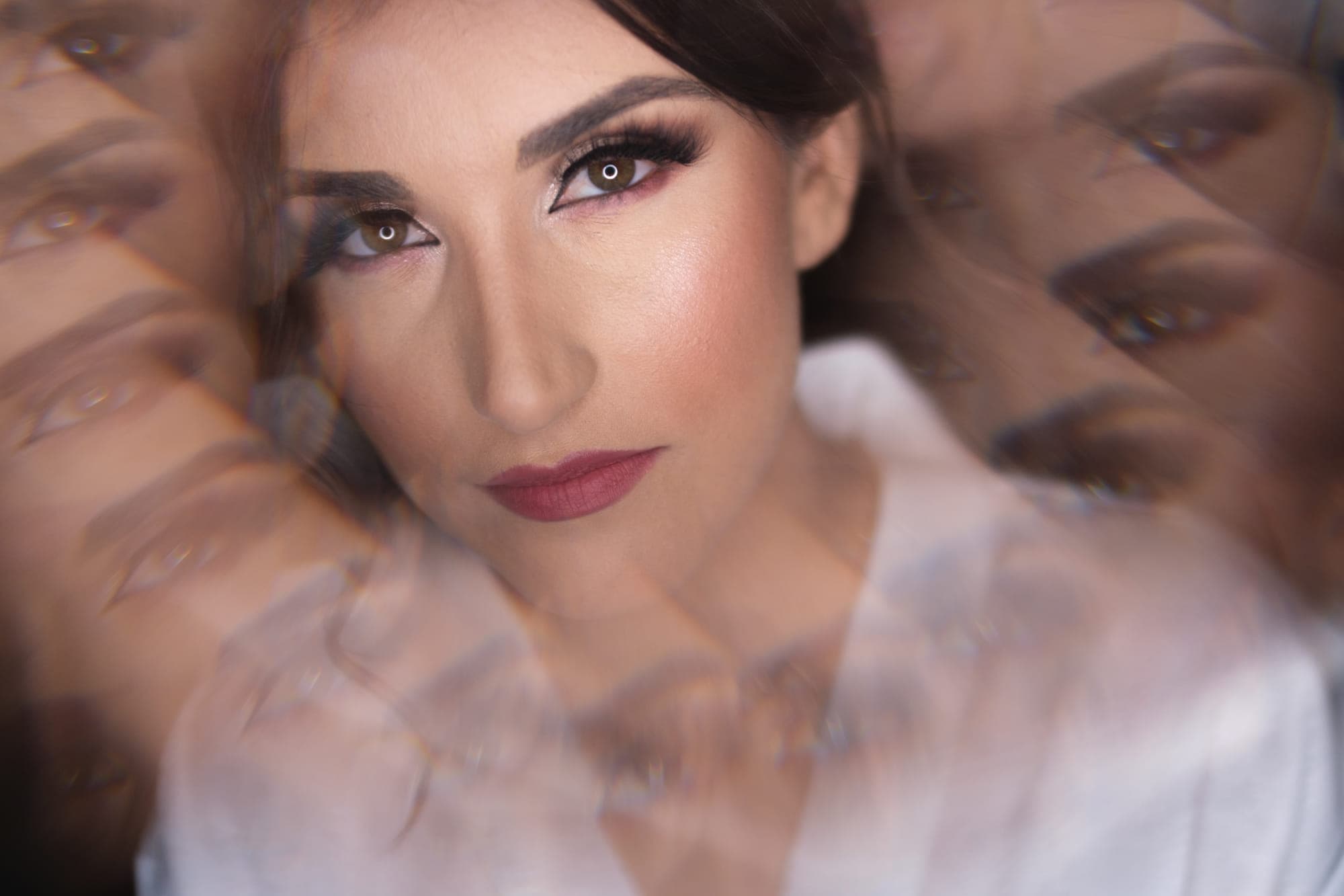 a bride photographed through a veil, her reflection repeating around her, straight out of camera