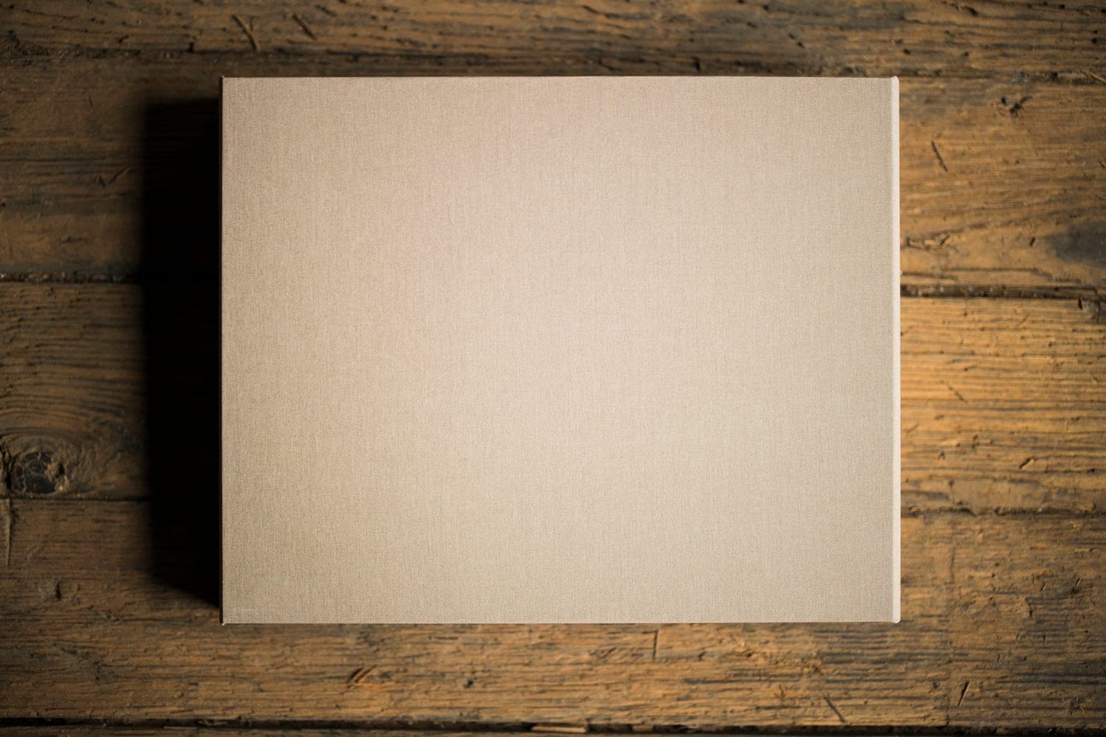 The closed linen presentation box photographed from above on reclaimed wood