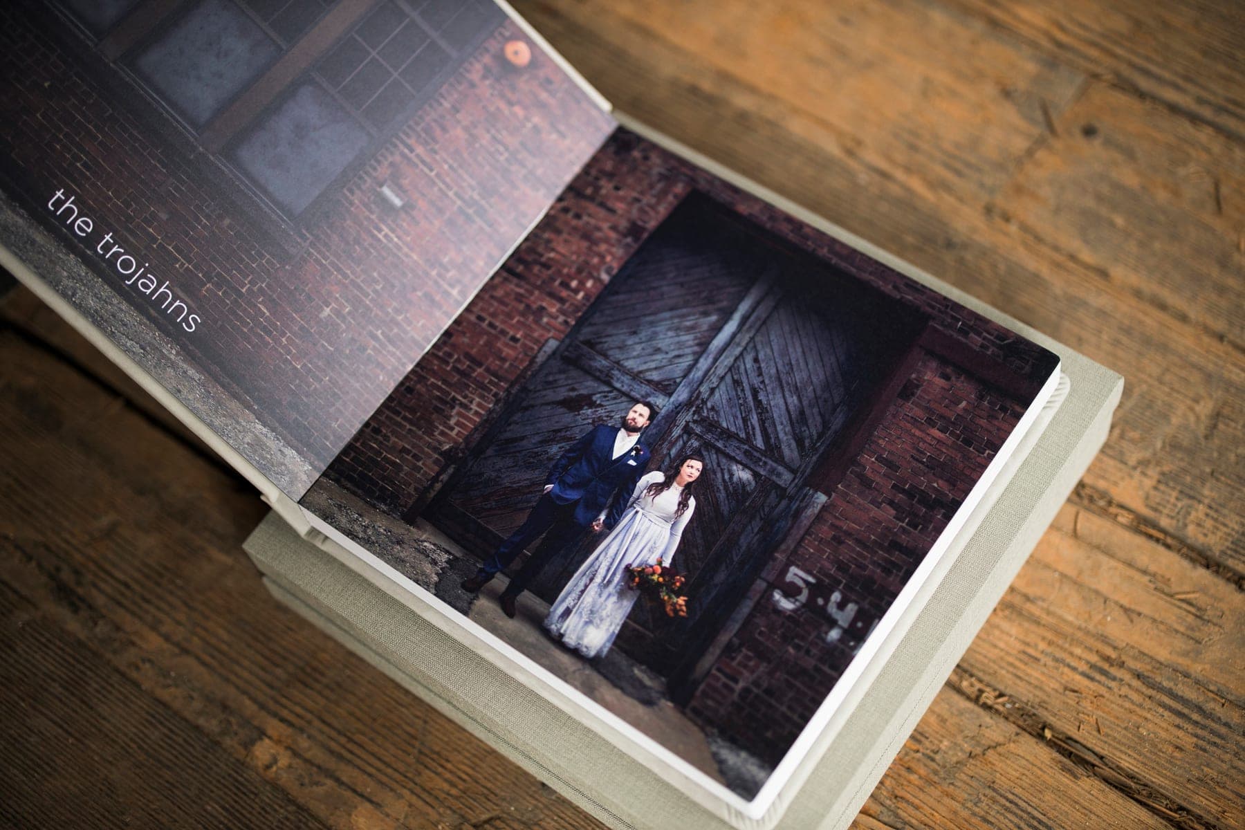 An album opened flat on a wooden table, a full-bleed photograph running across the spread