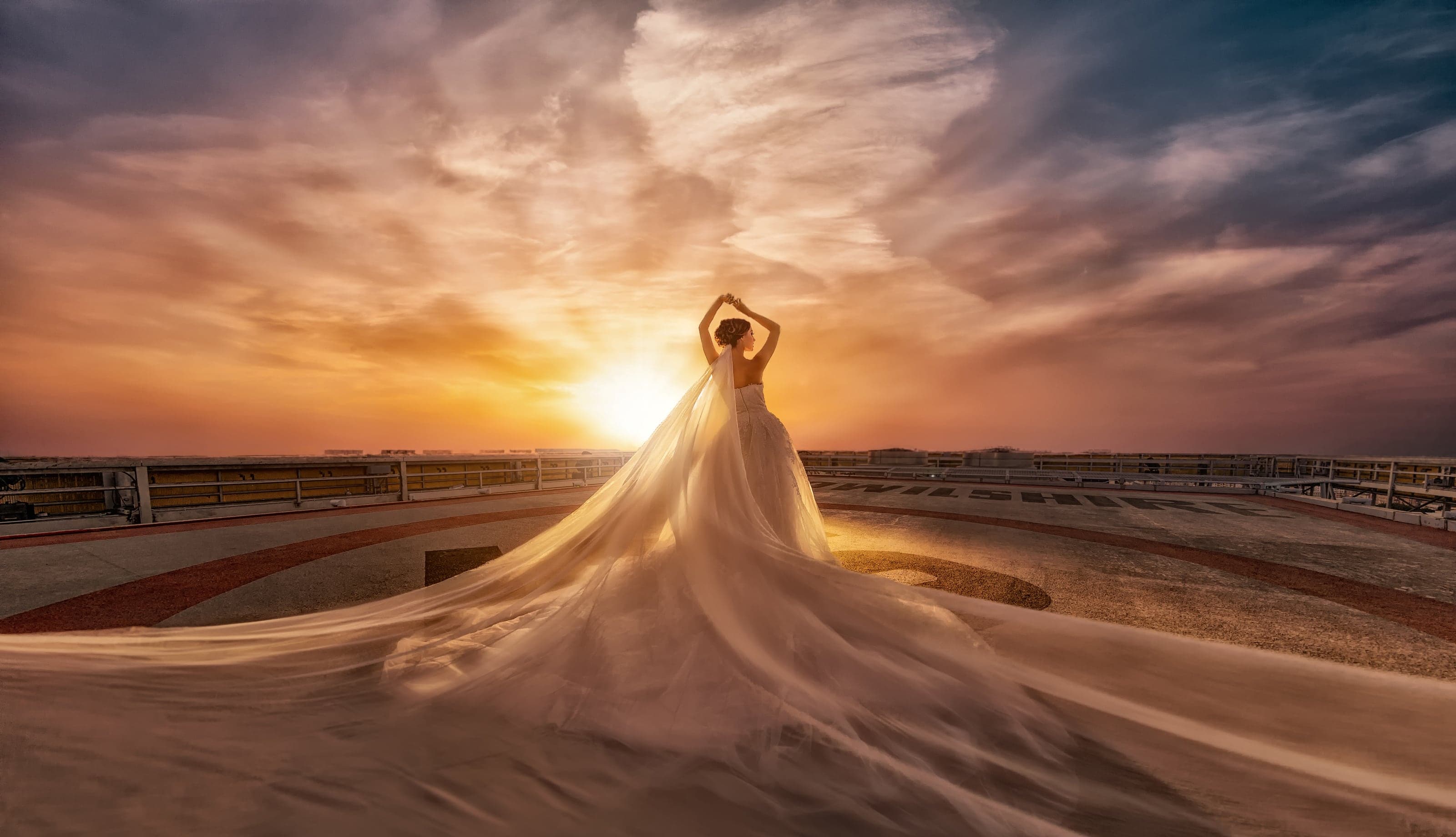 Couple at golden hour on a rooftop, the sun low over an open horizon