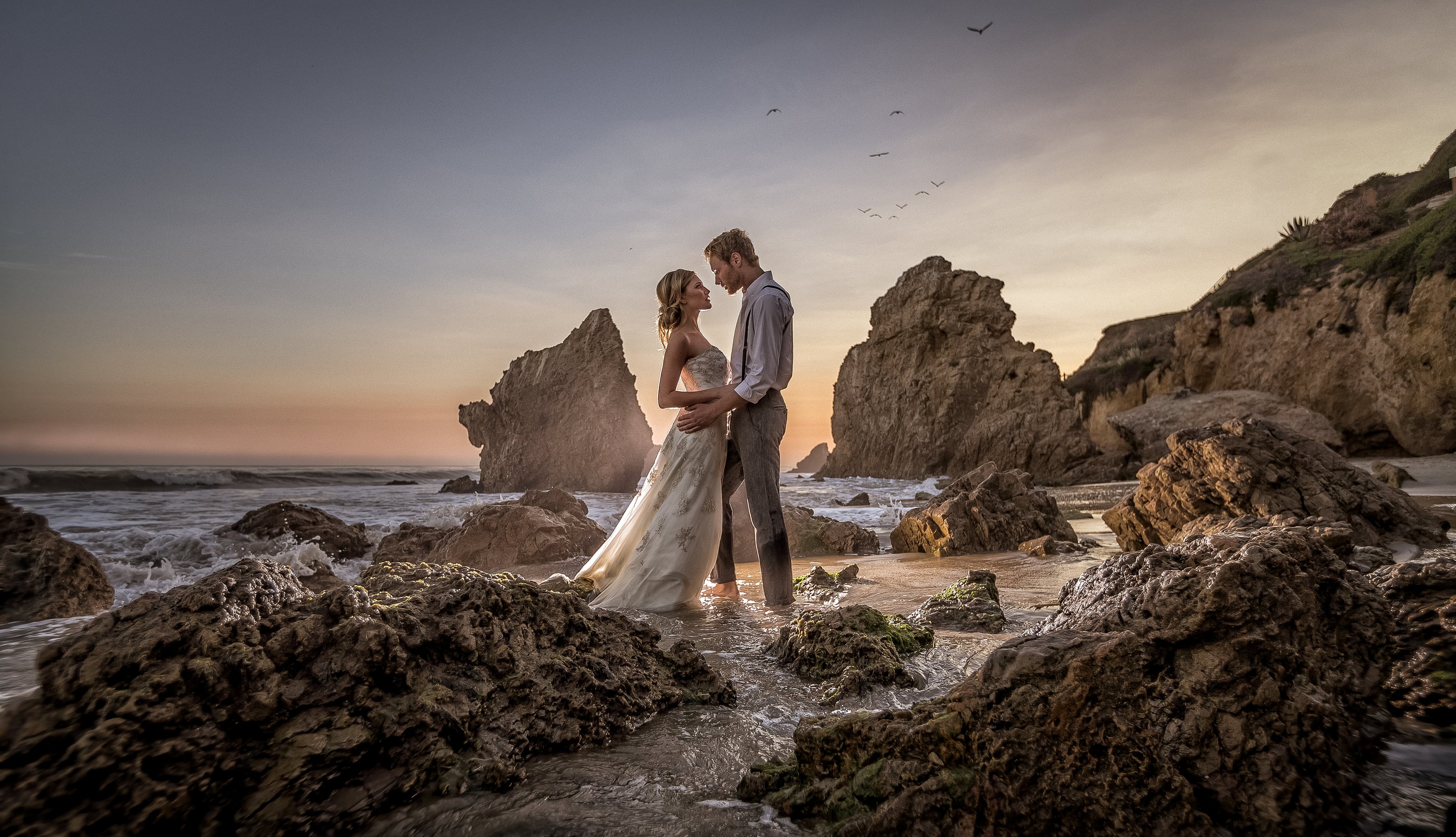 Bride and groom among the sea stacks of El Matador Beach at sunset