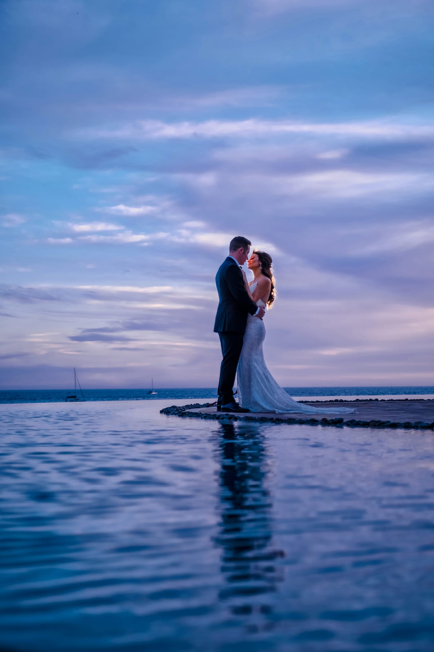 A bride and groom beside an infinity pool at Grand Solmar in Cabo