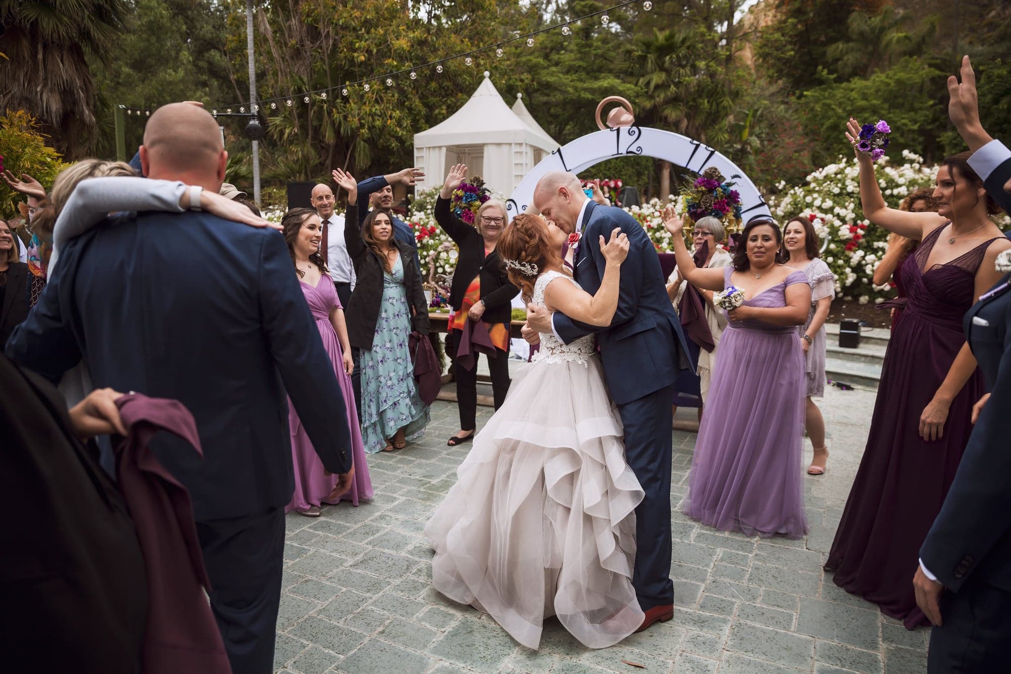 Wedding couple dancing with guests in the garden
