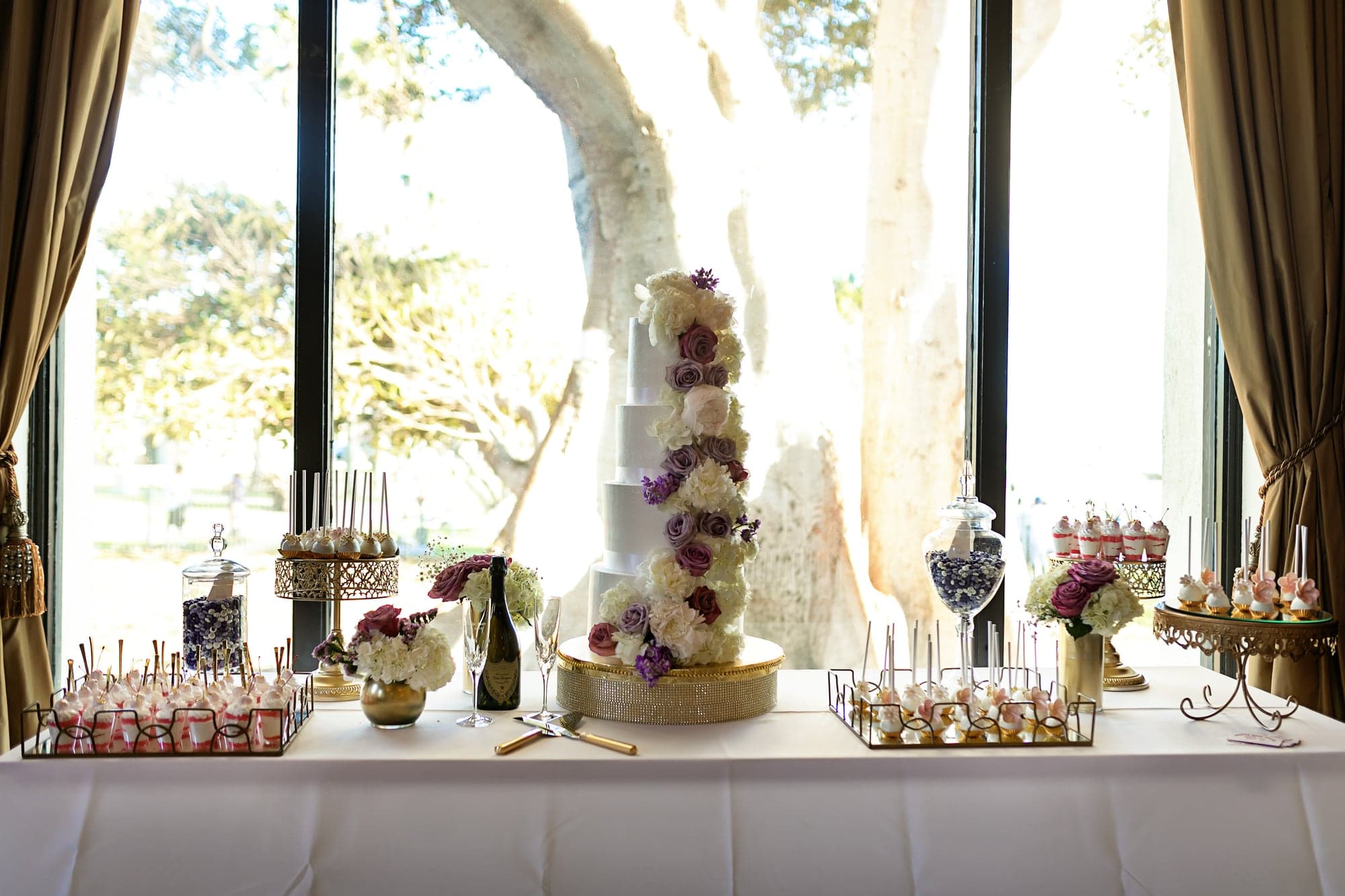 White and lavender floral reception details beside tall windows
