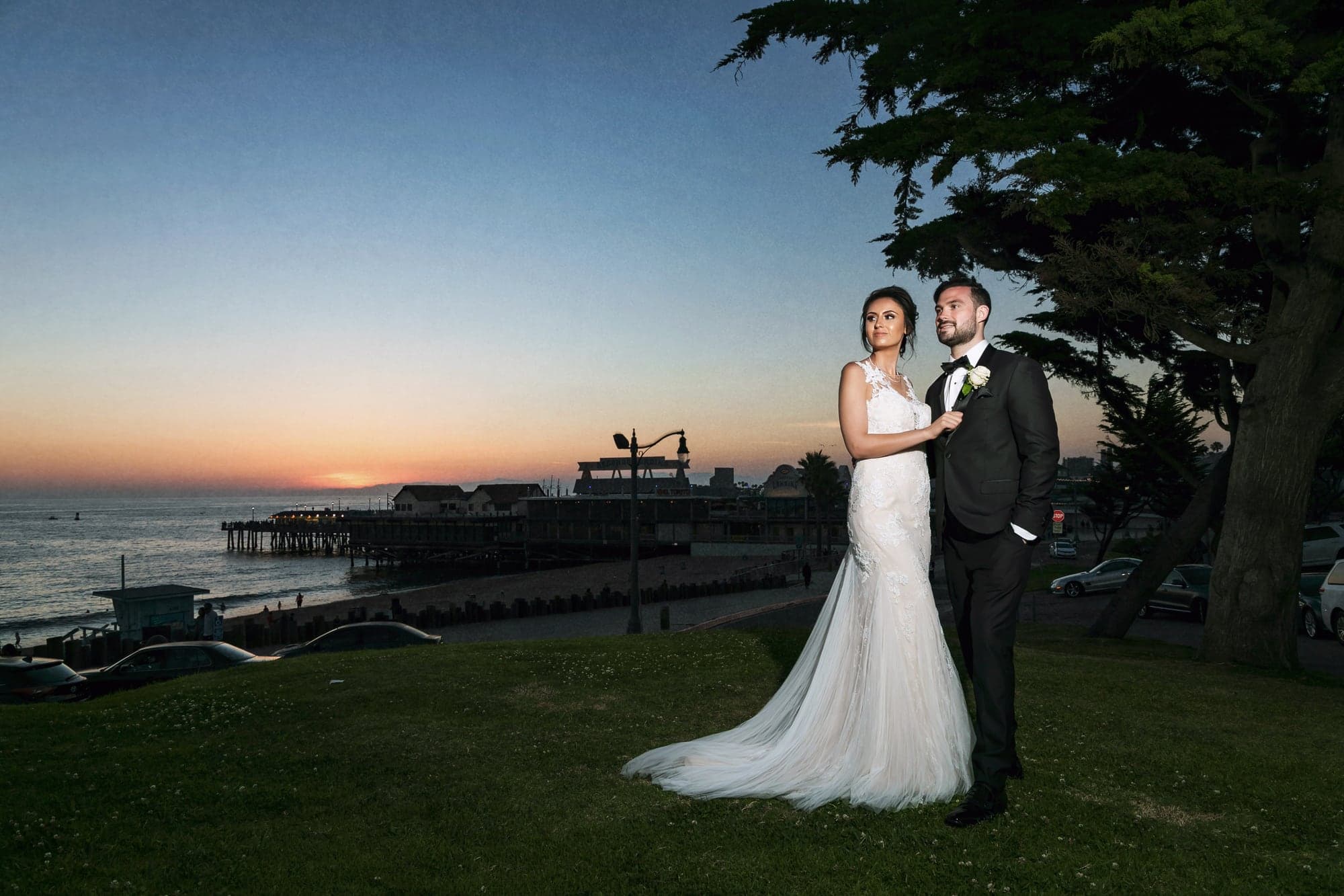 Tamara and Kevin posing beside the ocean at sunset