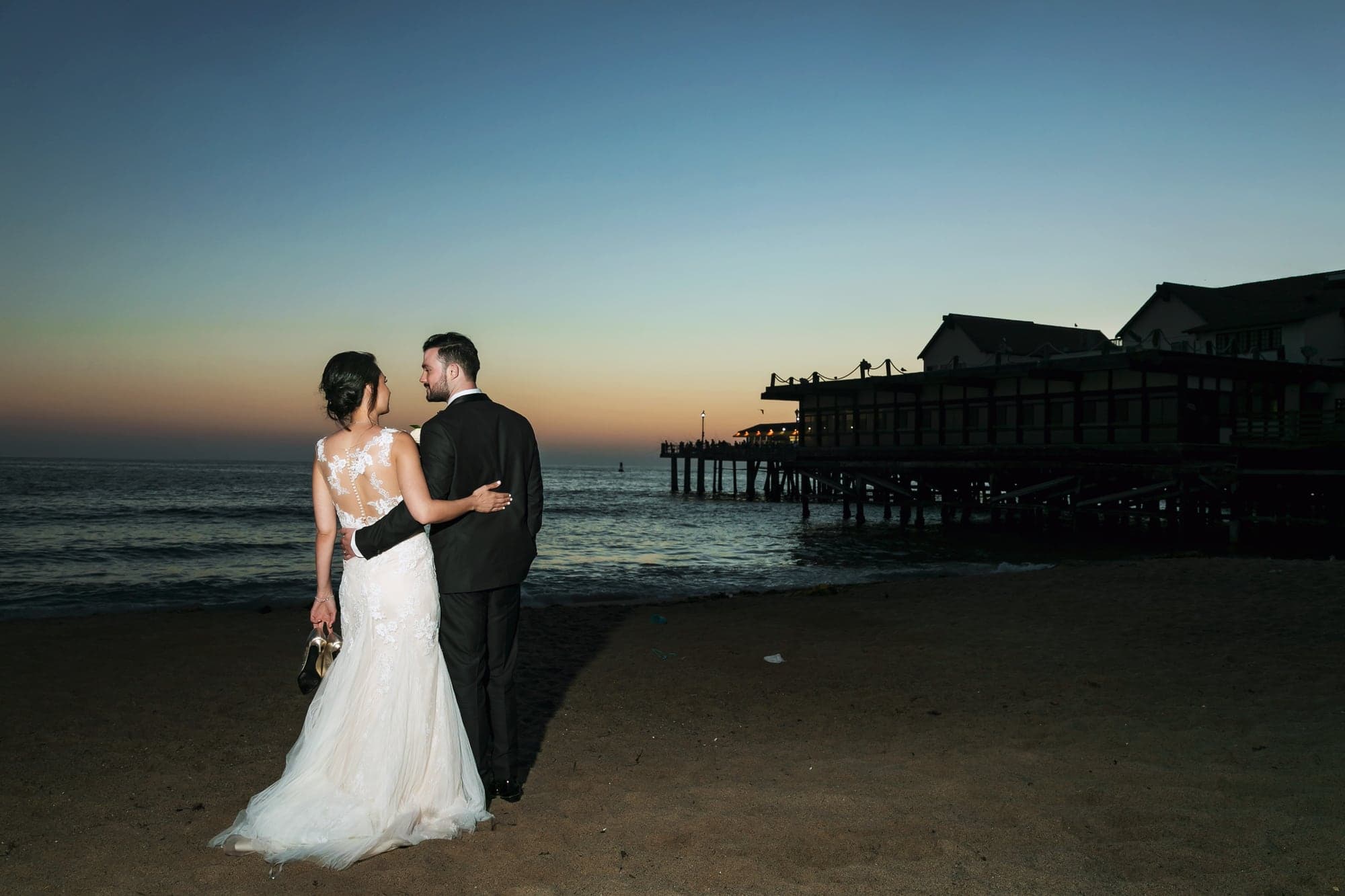 Tamara and Kevin embracing with the Redondo Beach pier behind them