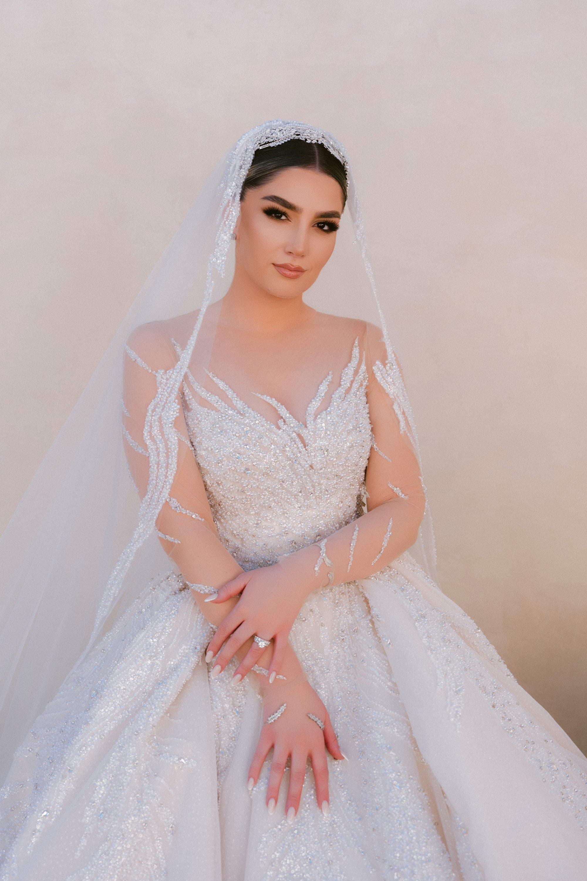 Bridal portrait of the bride beneath her cathedral veil, hands clasped
