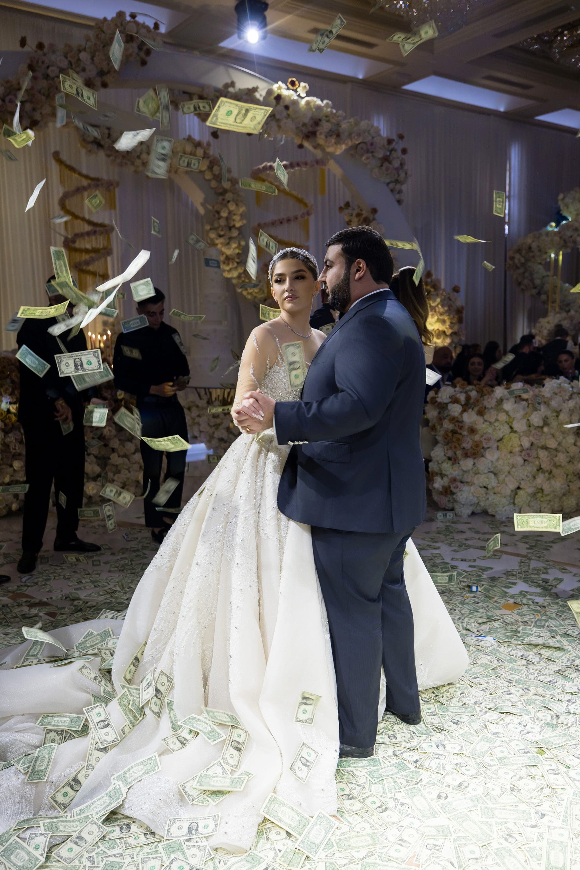 Money falling through the light over the bride and groom during their first dance