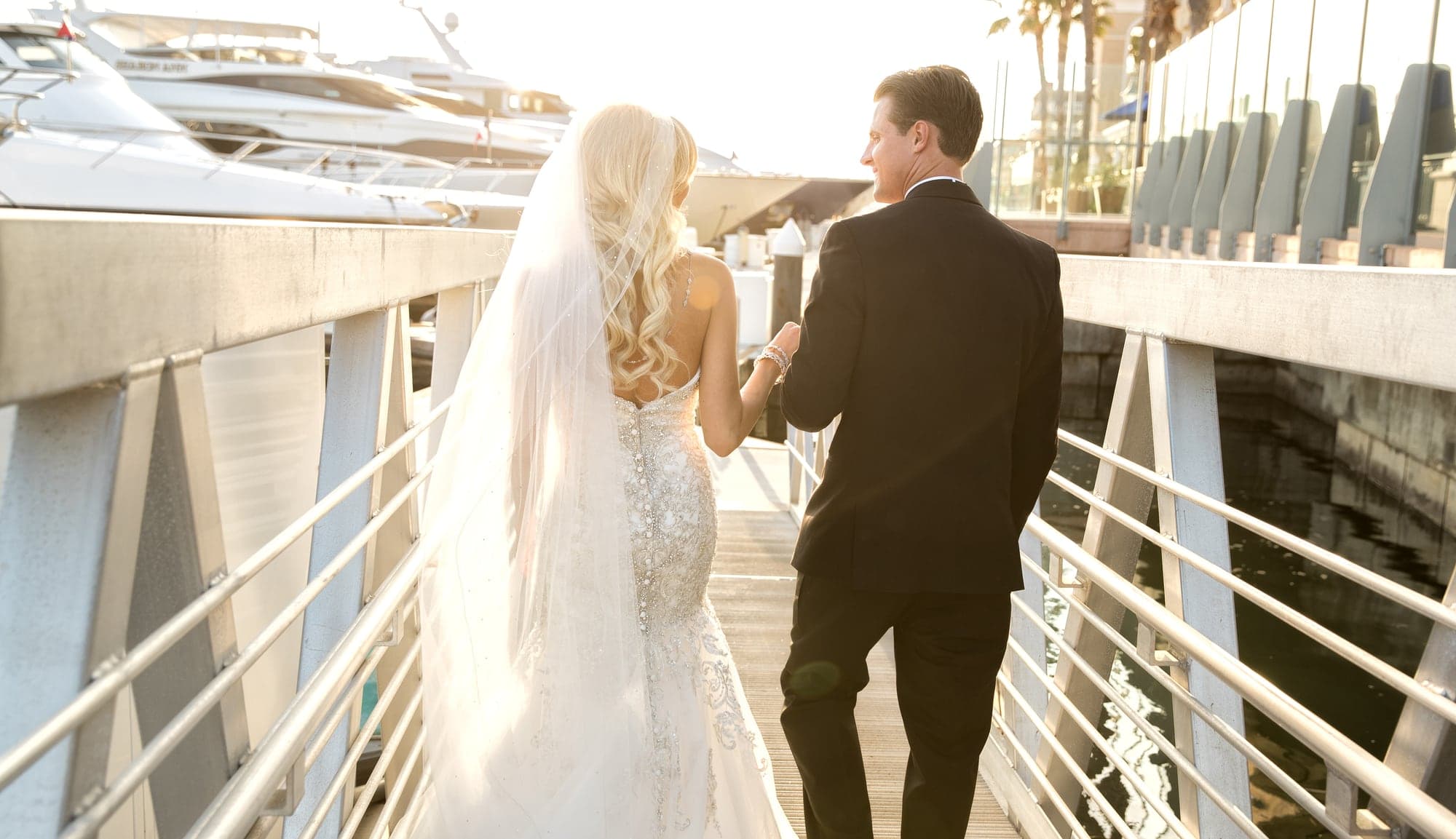 Melissa and Andrew walking beside the marina at Balboa Bay Club