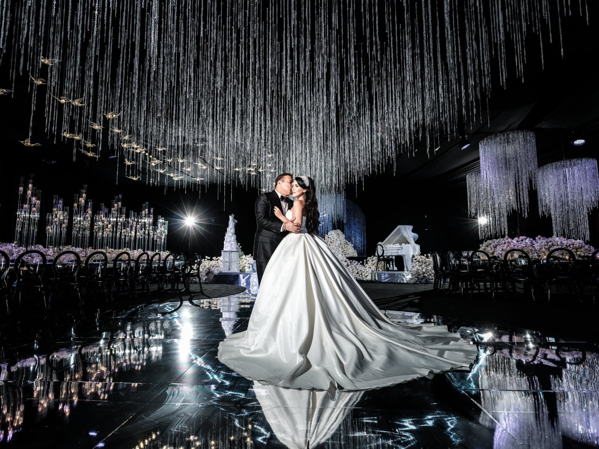 Ghazal standing with her groom beneath suspended crystals in the Beverly Hilton ballroom