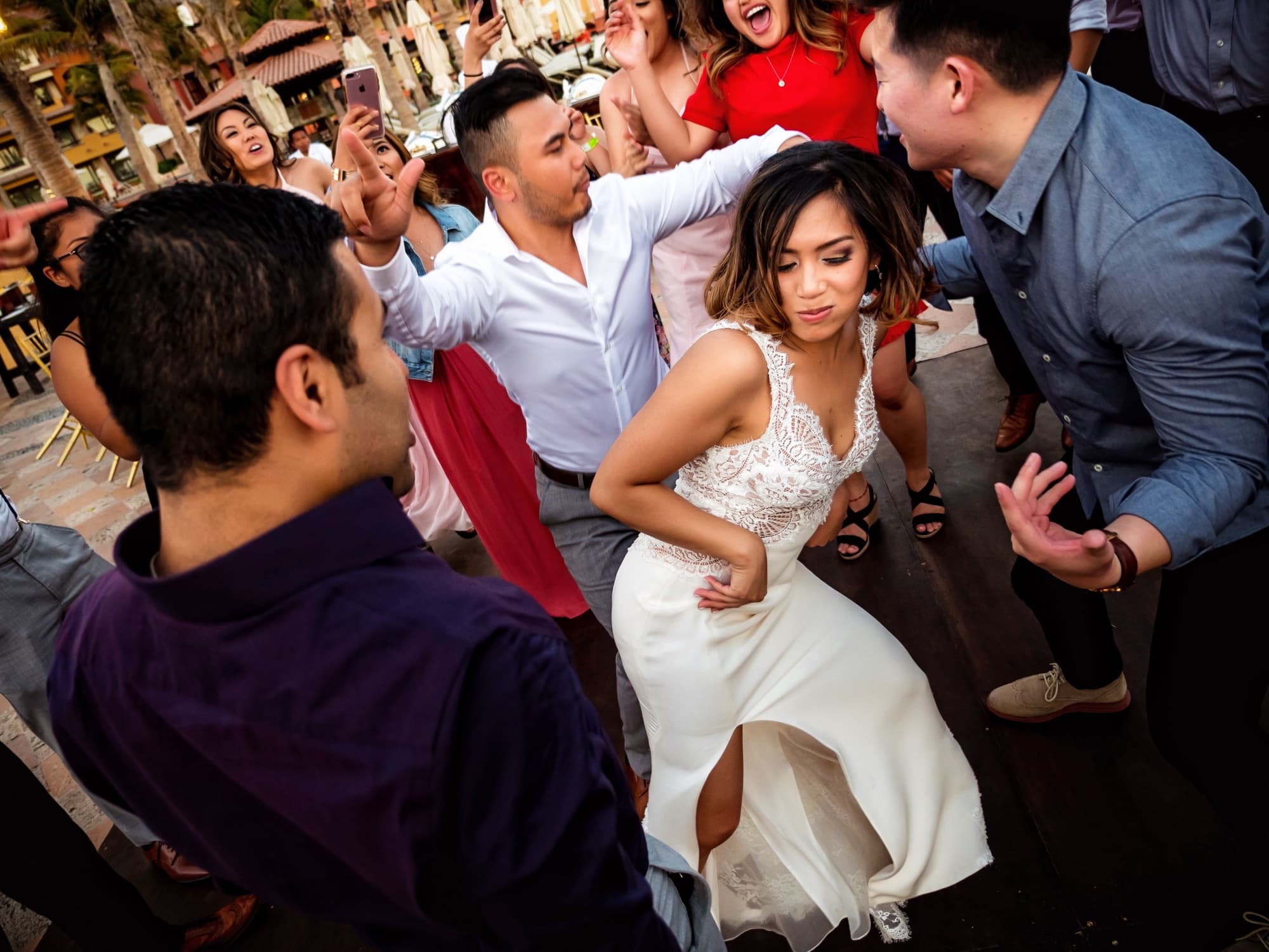 Kirsten dancing in the middle of a packed courtyard dance floor with friends at her Cabo reception