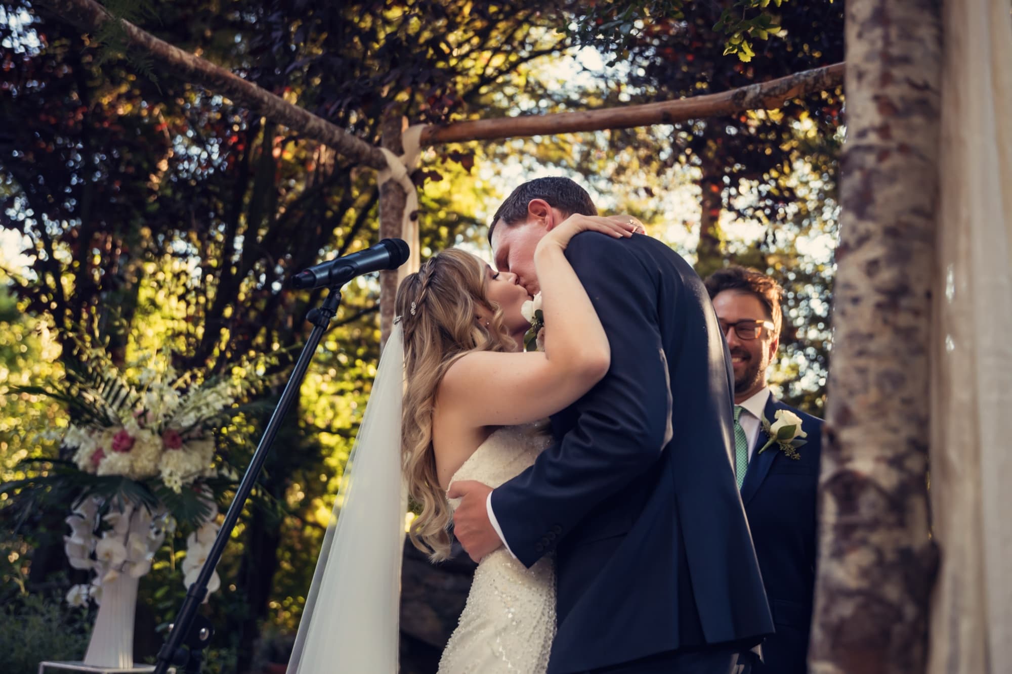 Monica and Colin's first kiss beneath the ceremony arch at Calamigos Ranch