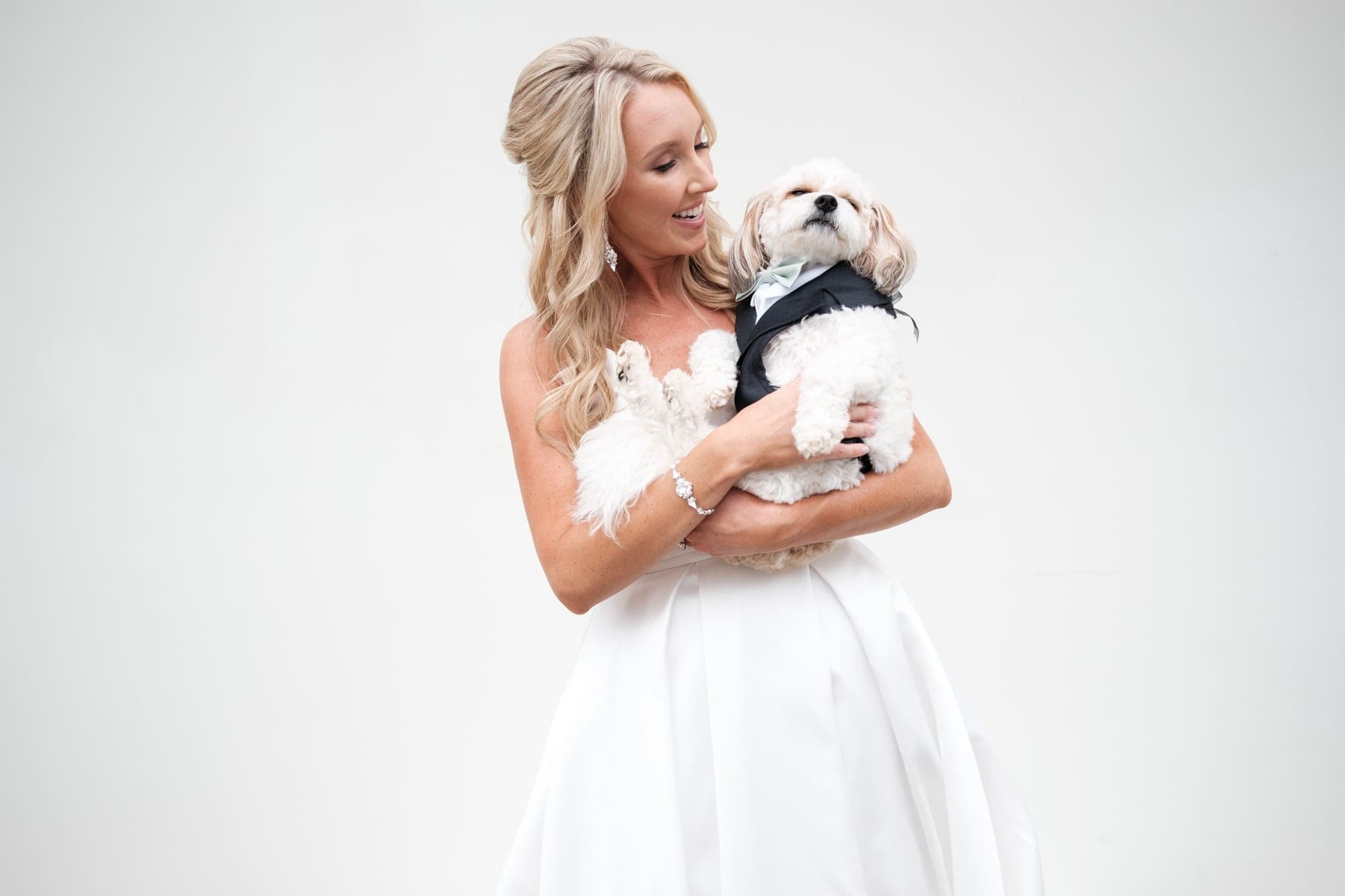 Karolina holding her dog during a bright bridal portrait before the Calamigos Ranch ceremony