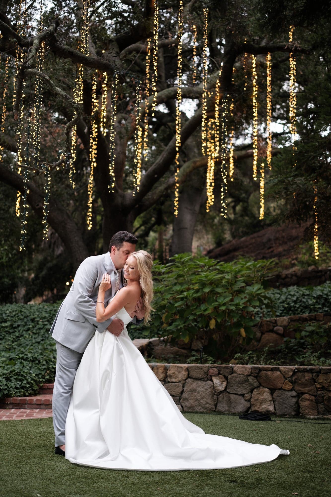 Karolina seated beneath the Calamigos Ranch oak trees with her wedding gown spread around her