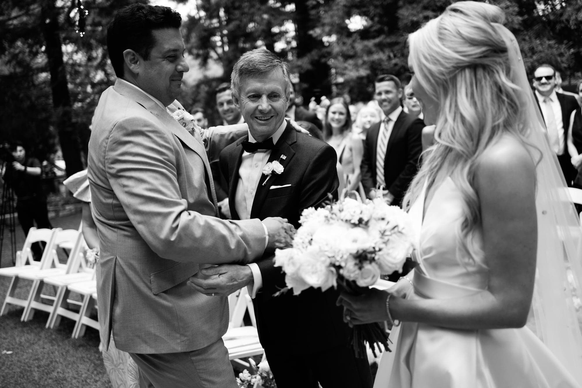 Karolina and Jonathan exchanging rings during their oak-grove ceremony at Calamigos Ranch