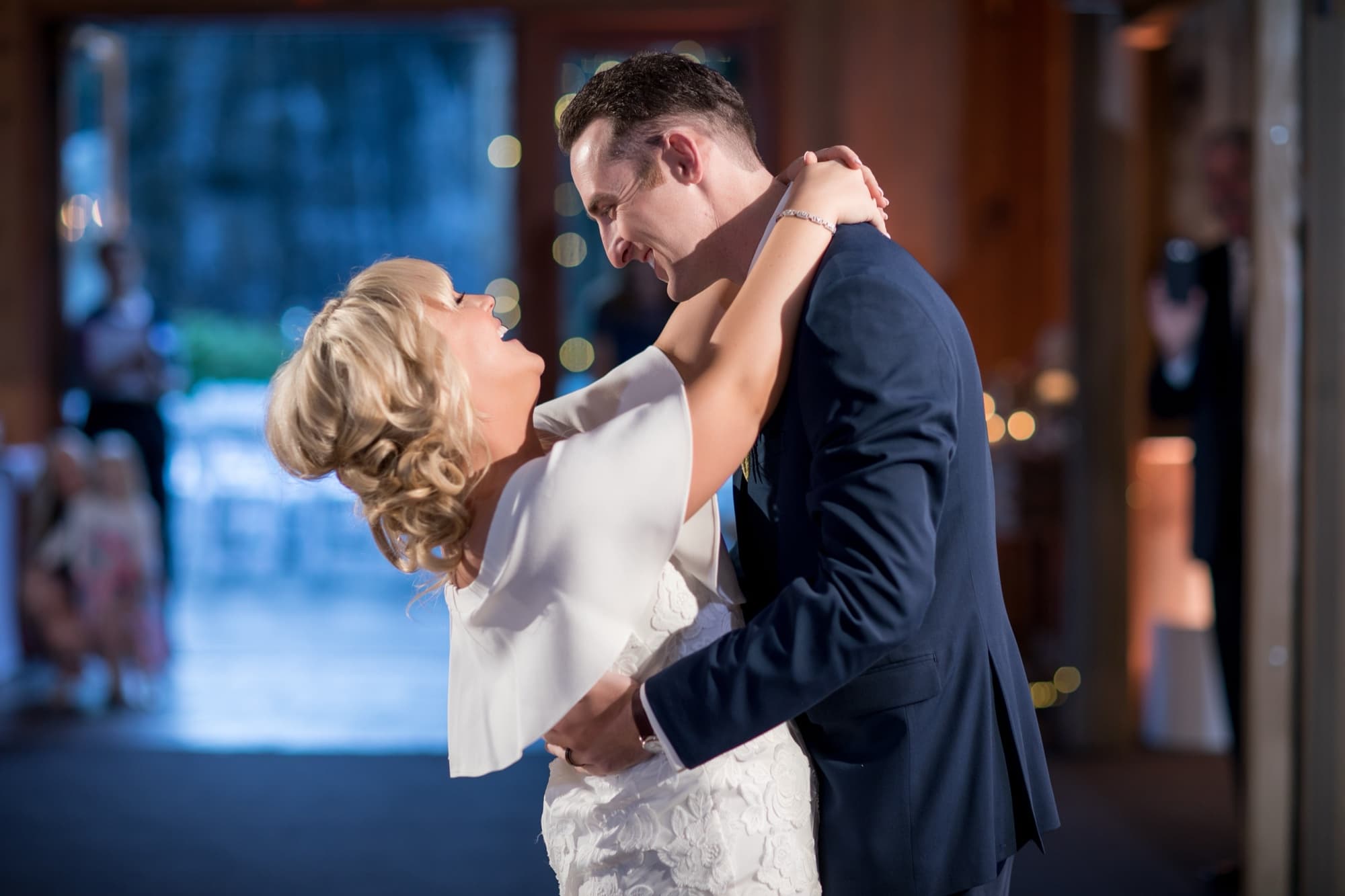 Groom dipping the bride during their first dance inside the wood-paneled reception room at Calamigos Ranch