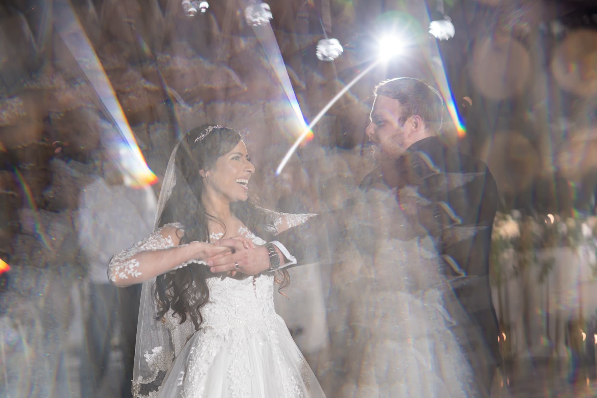 Tania and Cole sharing their first dance in the Callaway barrel room with string lights and lens flare around them