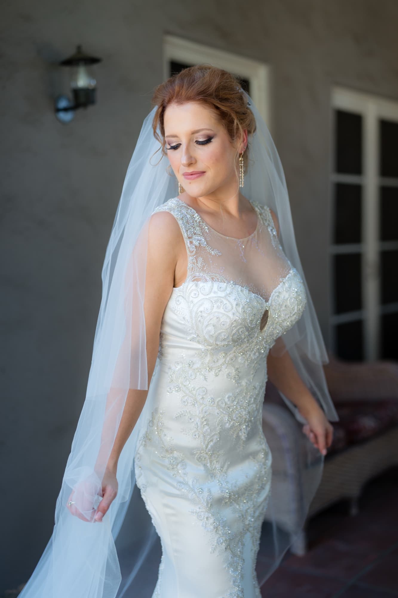 Briana in a beaded lace gown and fingertip veil in the window light of Carondelet House