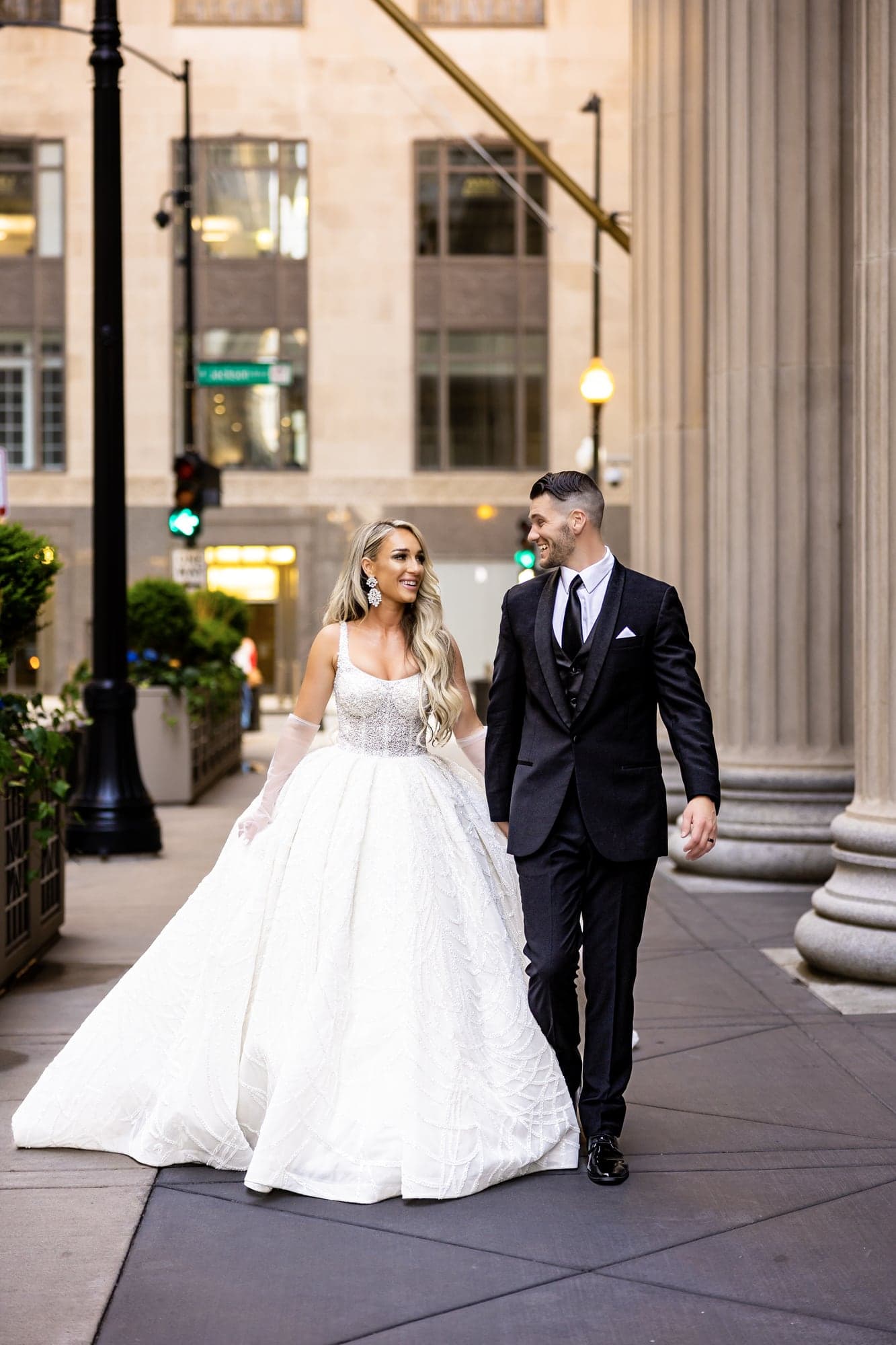 Katrinia and Dane walking together among the stone columns of downtown Chicago